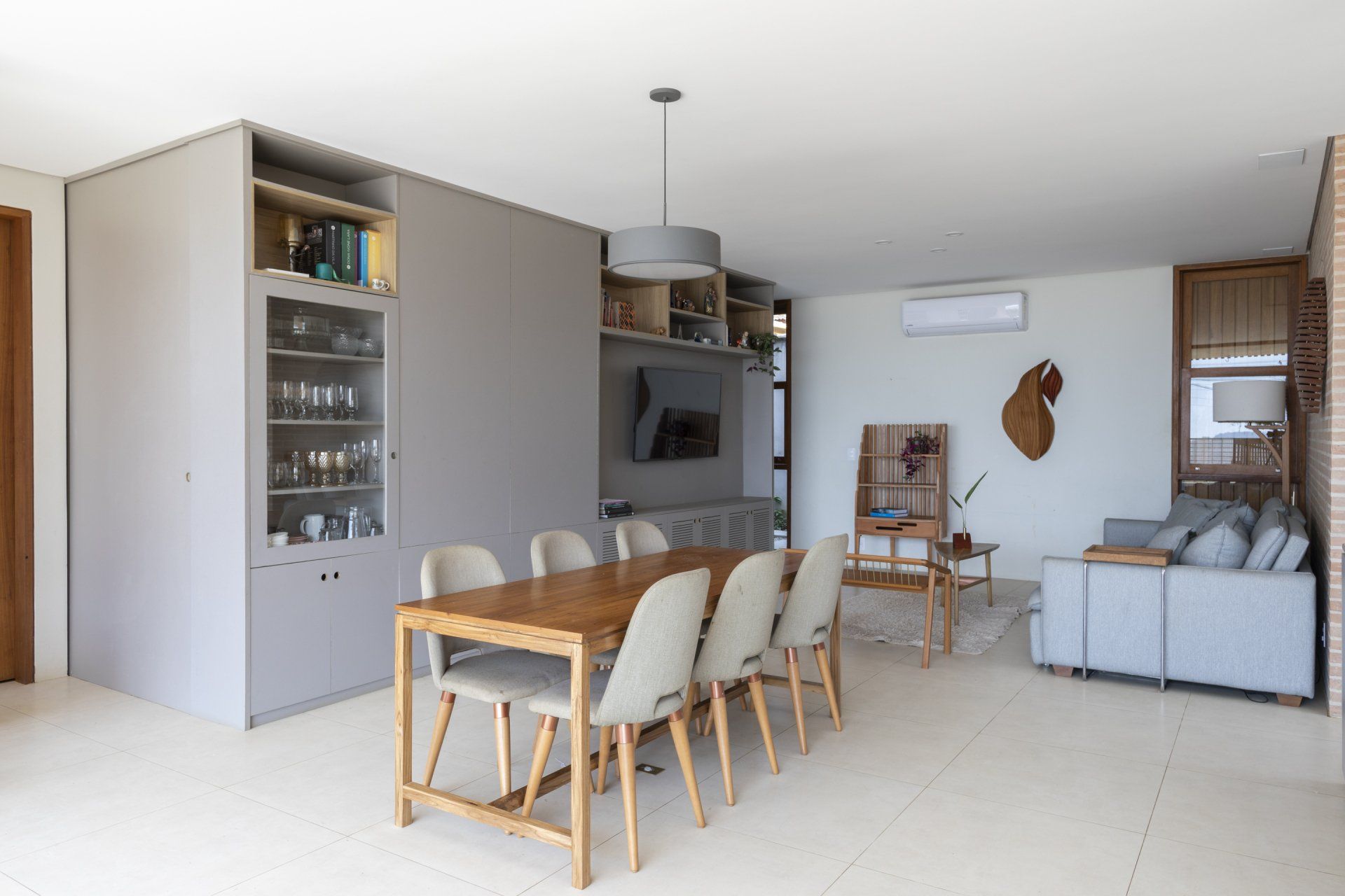 Há uma mesa de jantar e cadeiras no meio da sala.