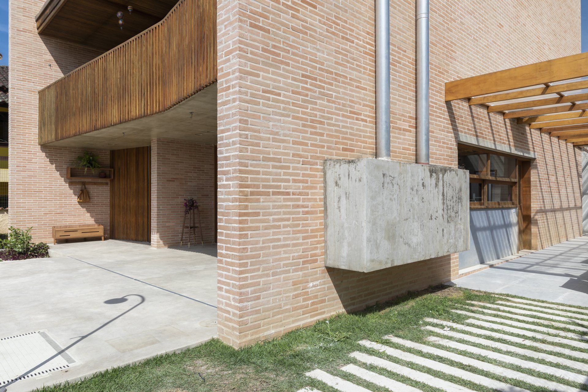 Um prédio de tijolos com varanda de madeira e passarela de concreto.