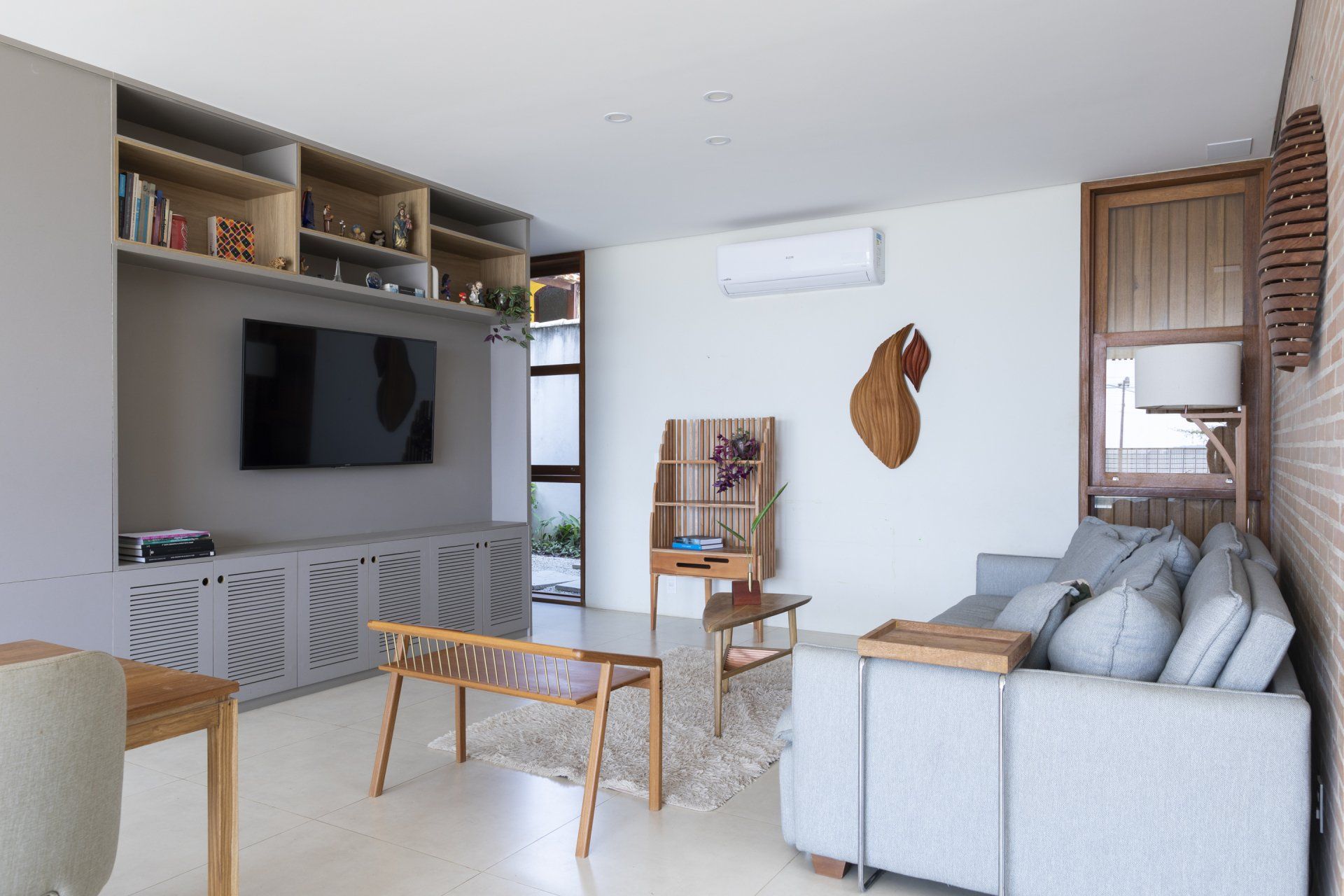 Uma sala de estar com sofá, mesa e televisão.