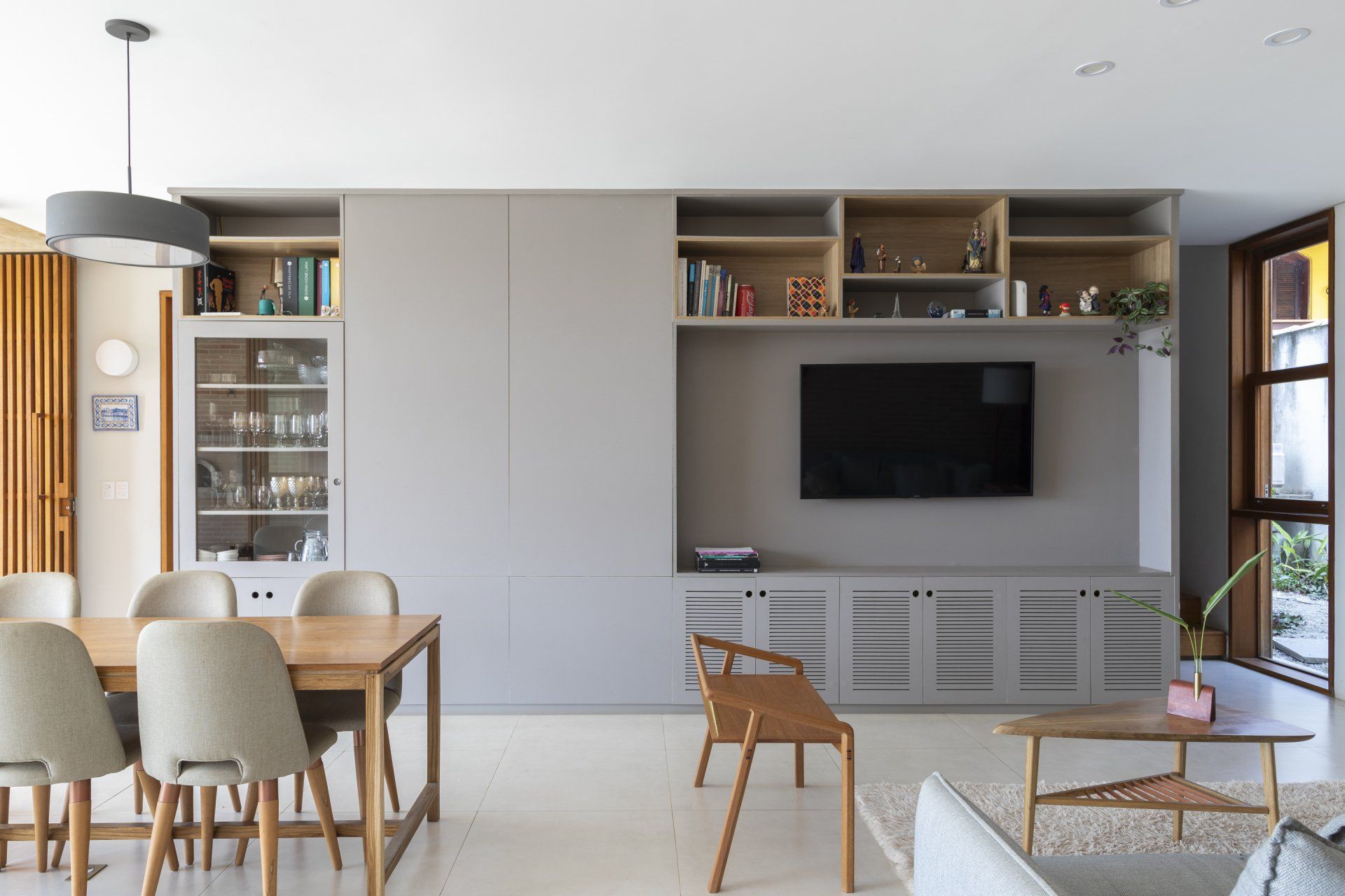 Uma sala de estar com mesa de jantar, cadeiras e TV de tela plana.