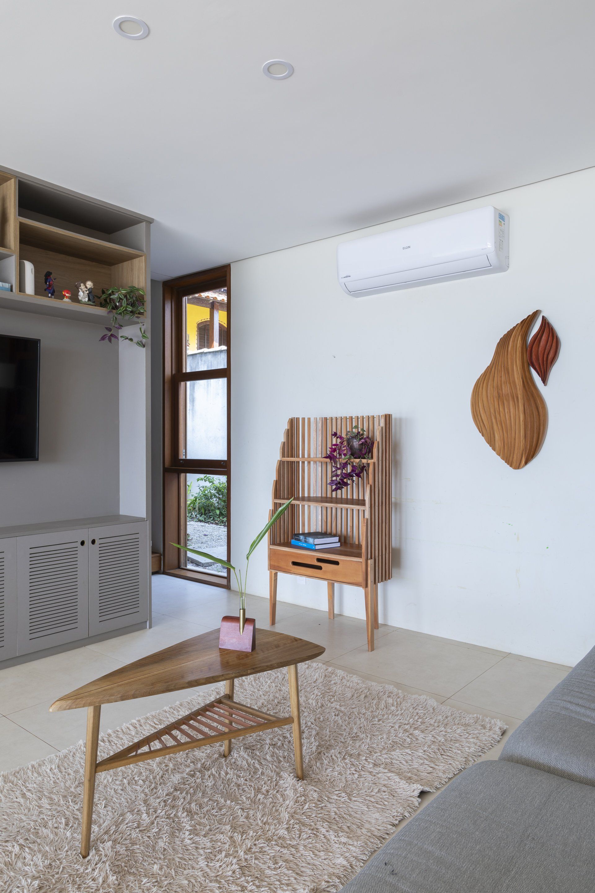 Uma sala de estar com sofá, mesa de centro e televisão.