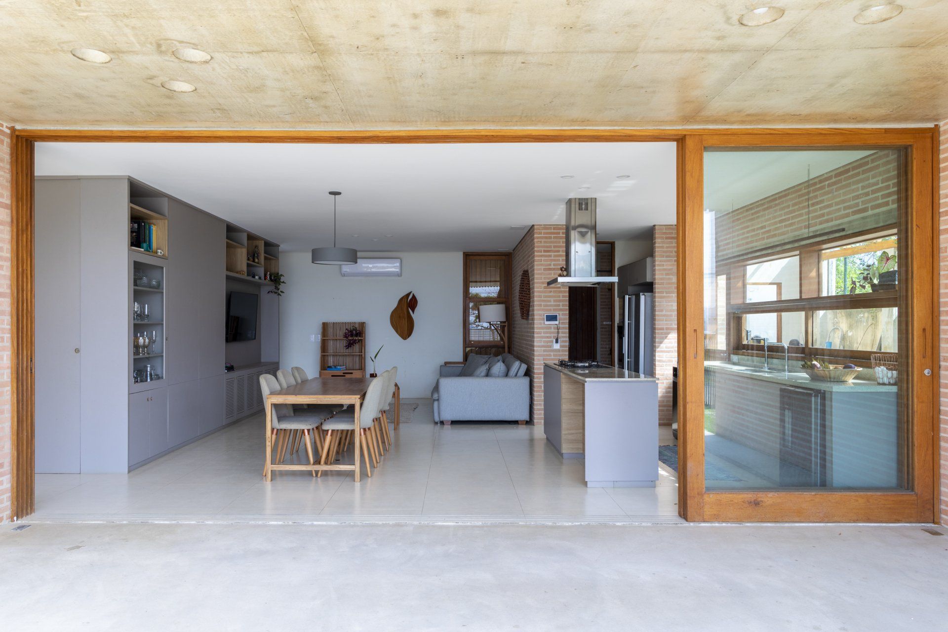 Há uma grande porta de vidro deslizante entre a sala e a cozinha.