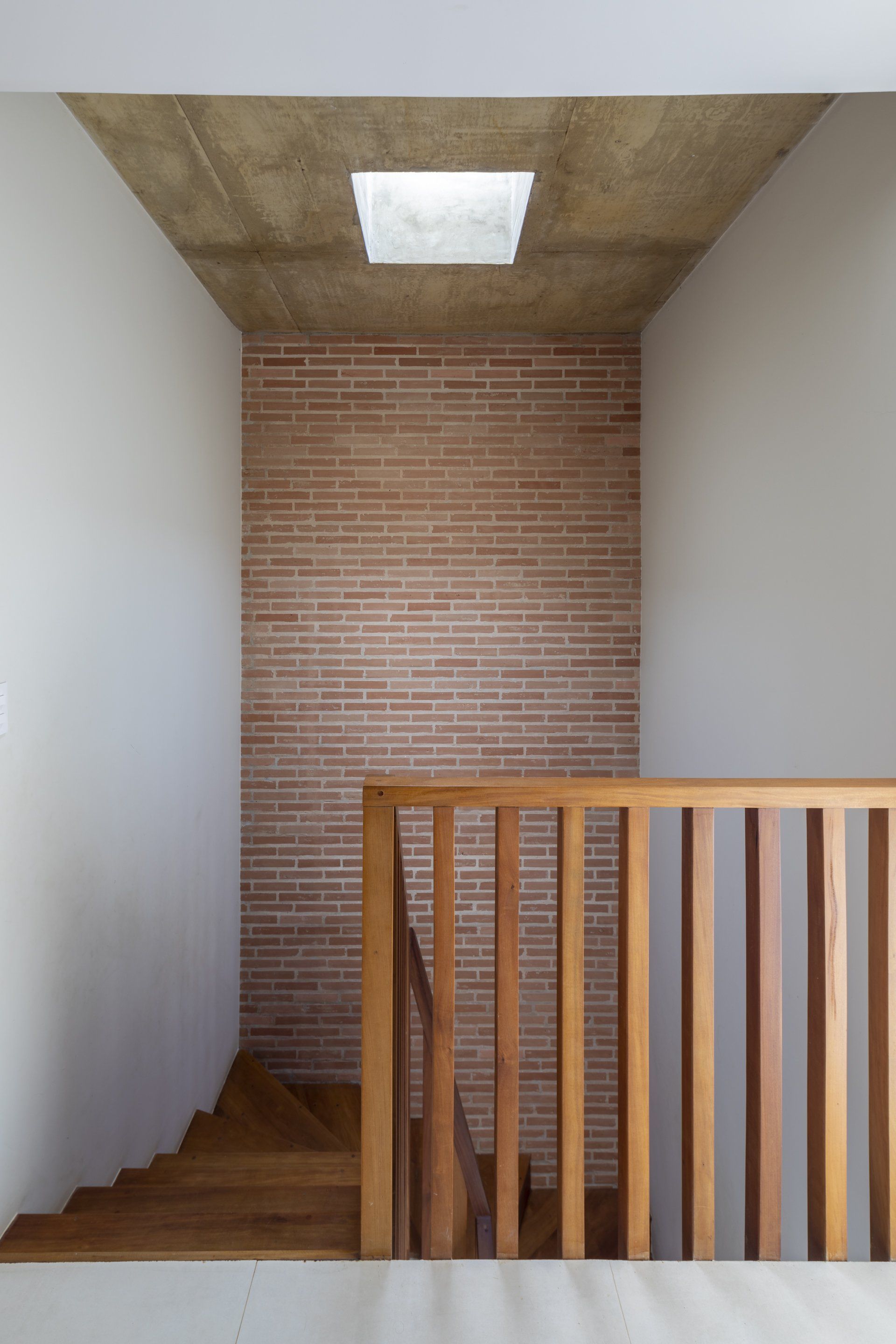 Uma escada com corrimão de madeira e parede de tijolos