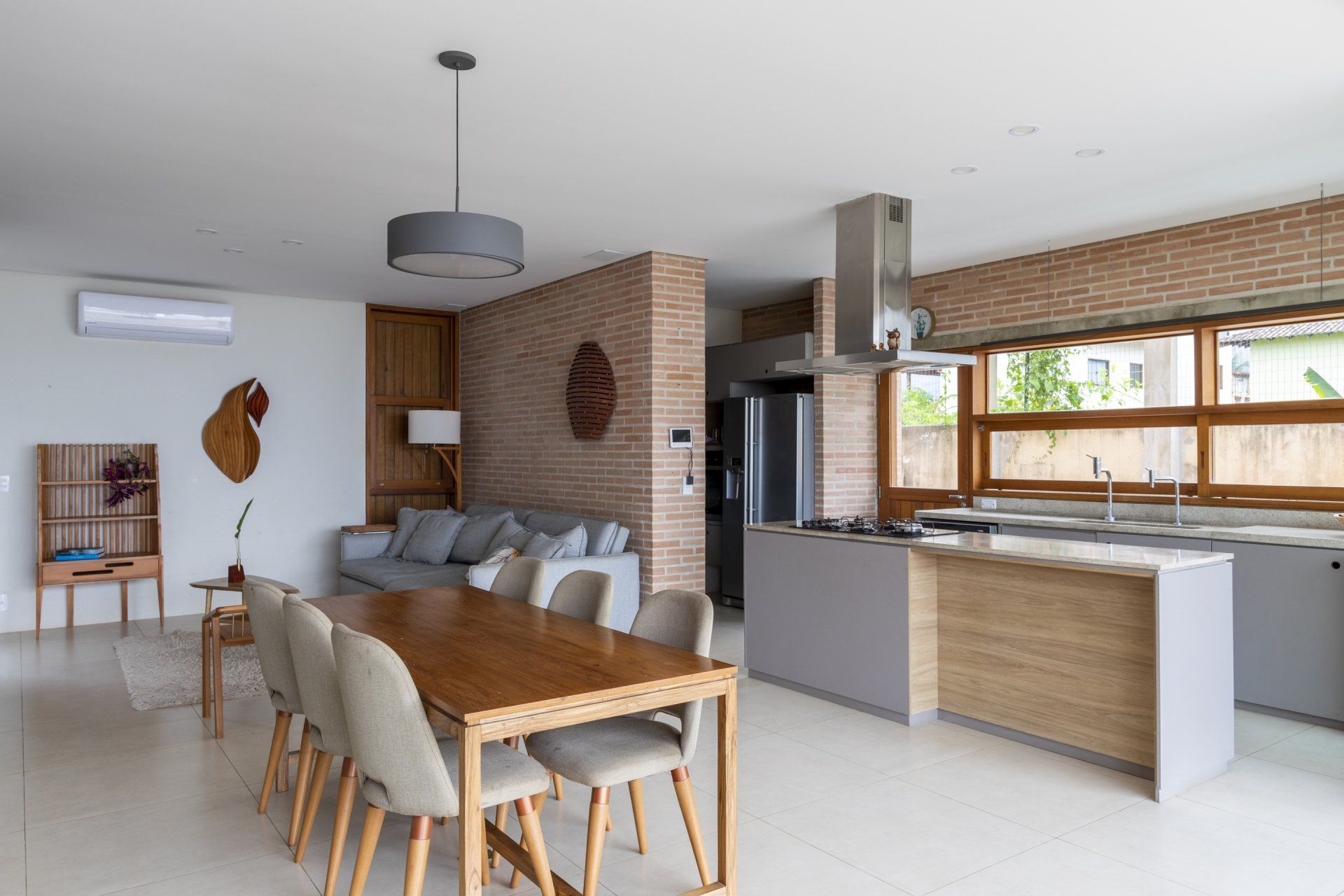 Uma sala de estar com mesa de jantar e cadeiras e uma cozinha.