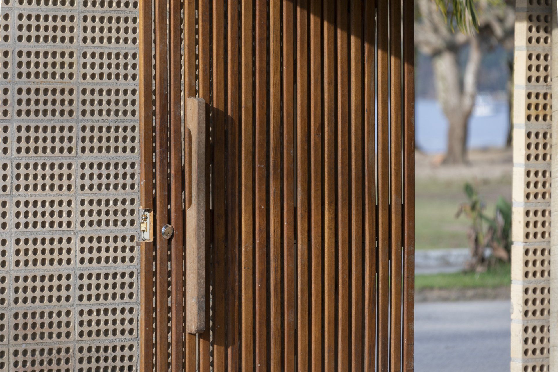 Um close de um portão de madeira com alça de madeira.