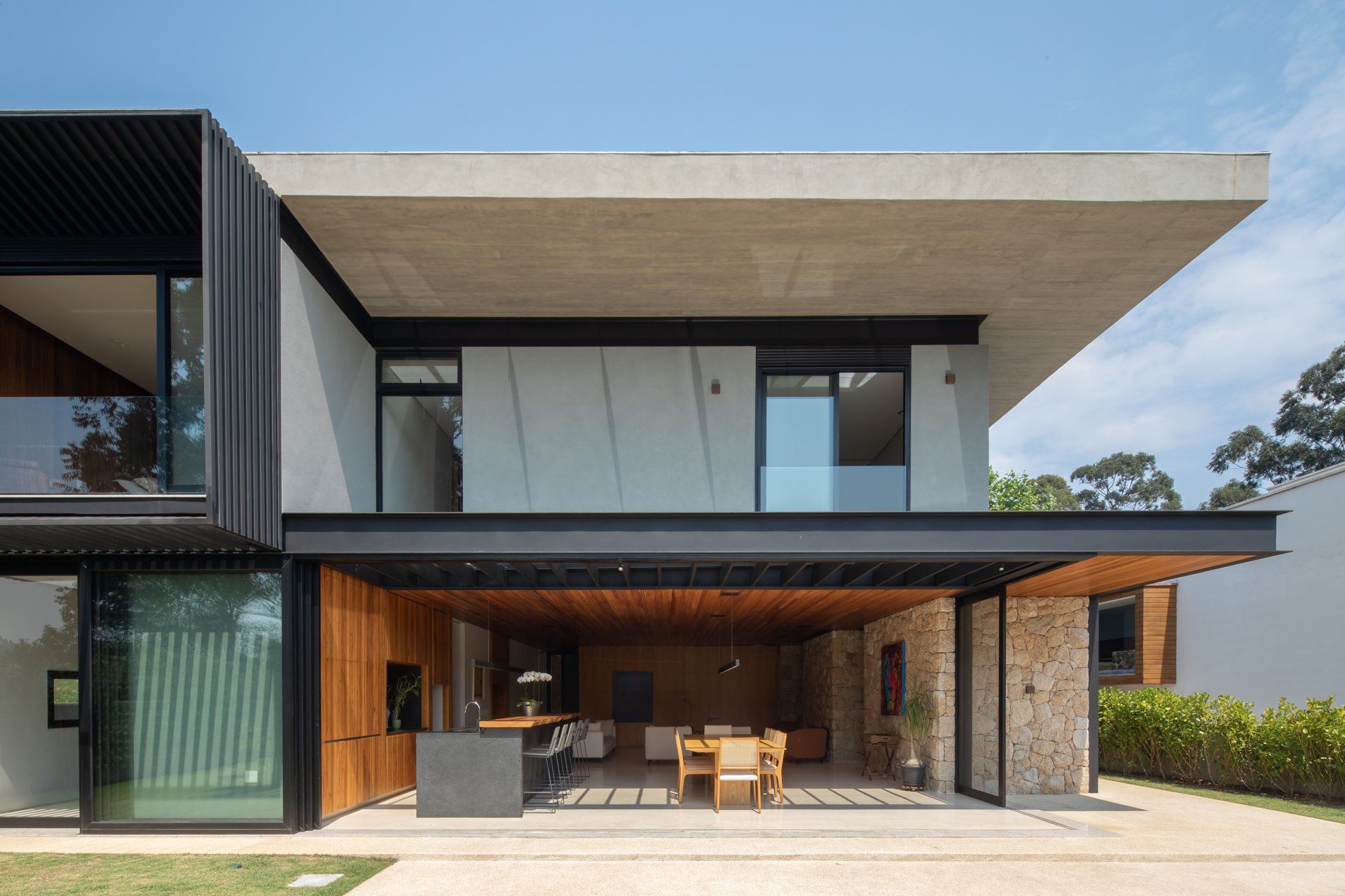 Uma casa moderna com muitas janelas e varanda.