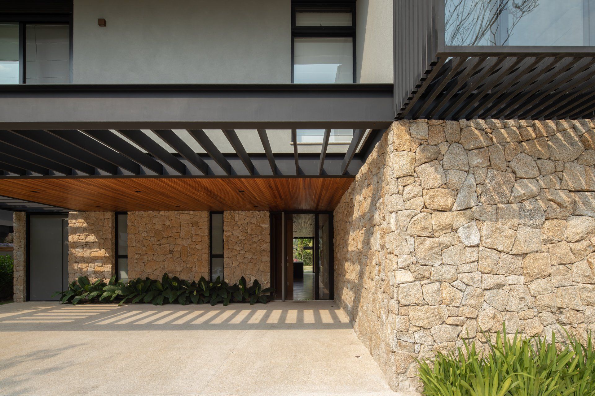 Uma casa moderna com parede de pedra e telhado de madeira