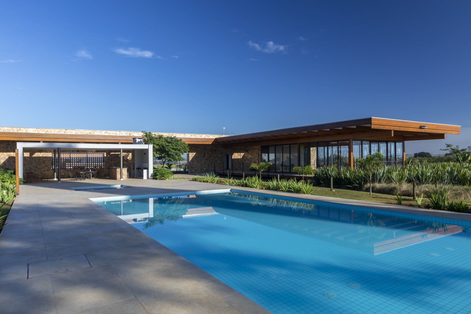 Há uma grande piscina em frente a uma casa.