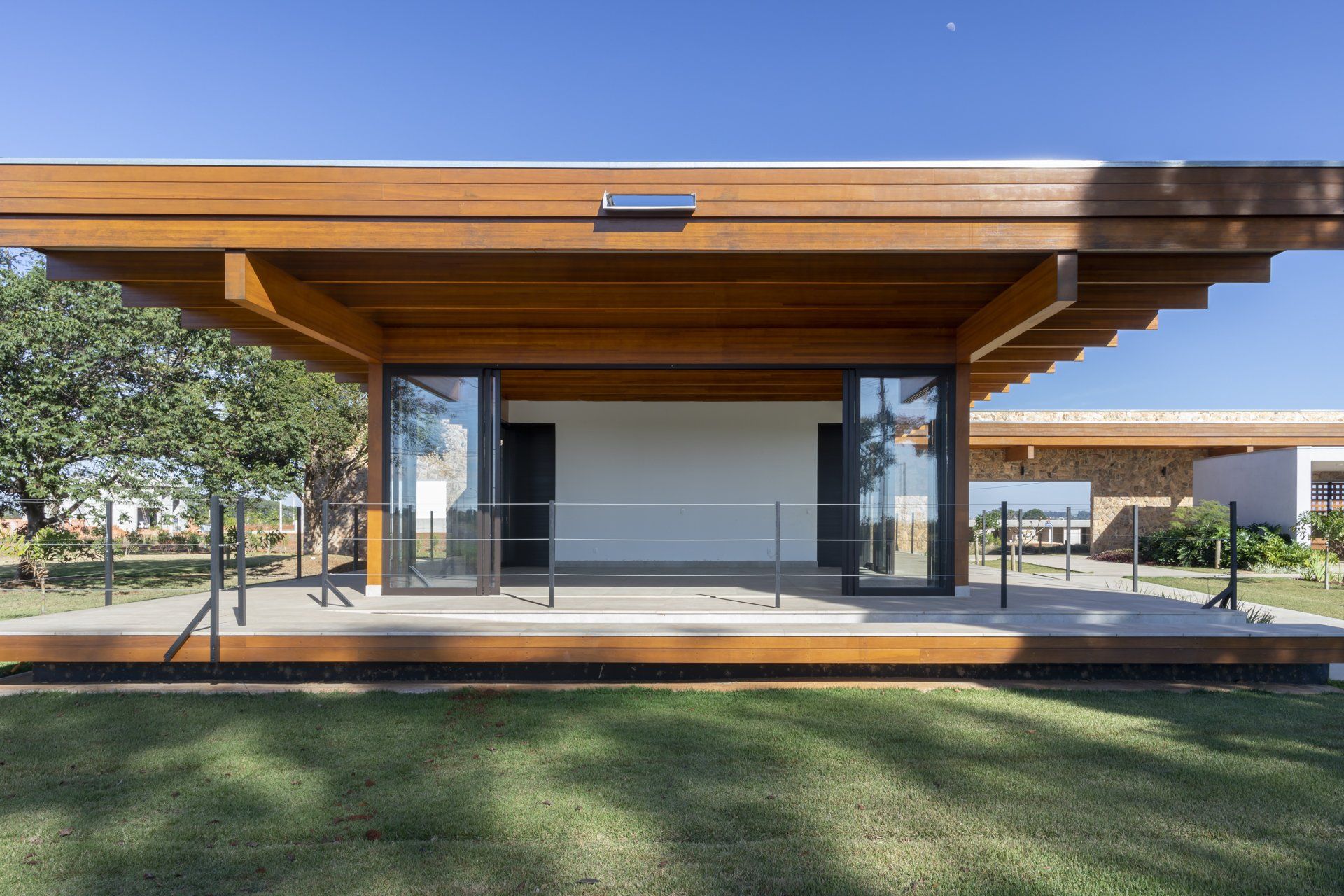 Uma pequena casa com telhado de madeira e portas de correr de vidro.