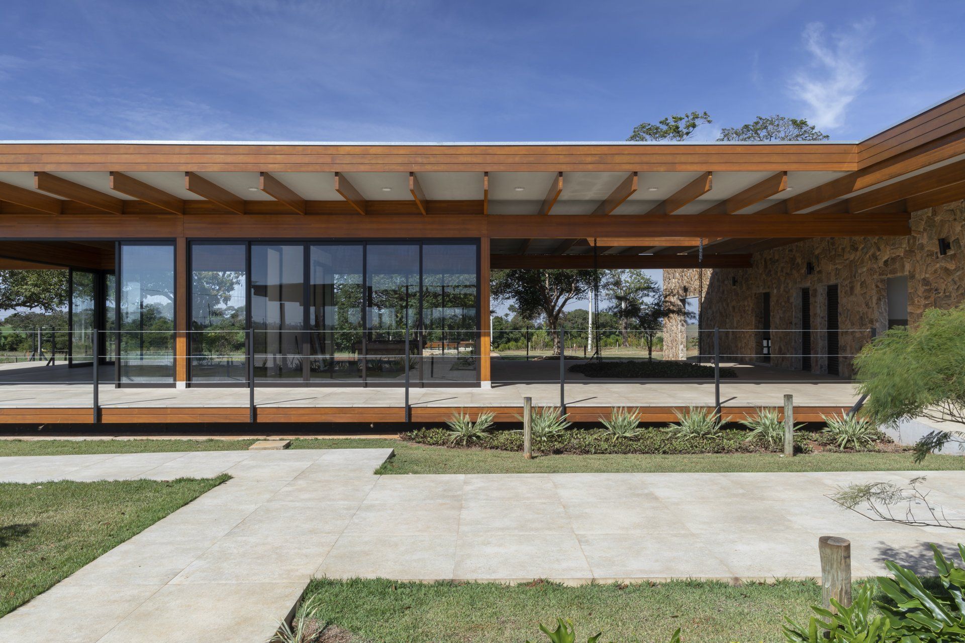 Uma casa grande com muitas janelas e uma passarela que leva até ela.