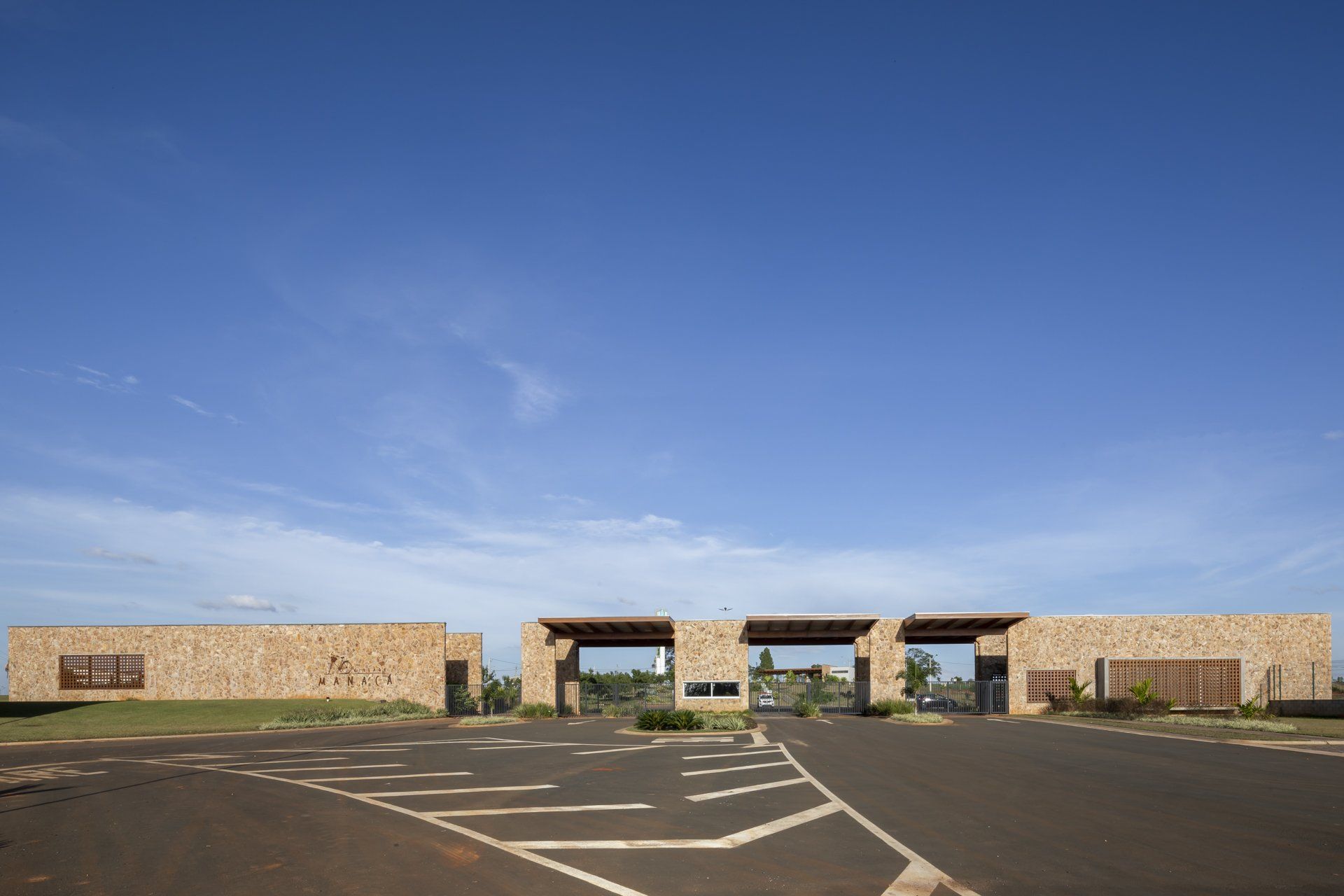 Um grande edifício de pedra com estacionamento em frente.