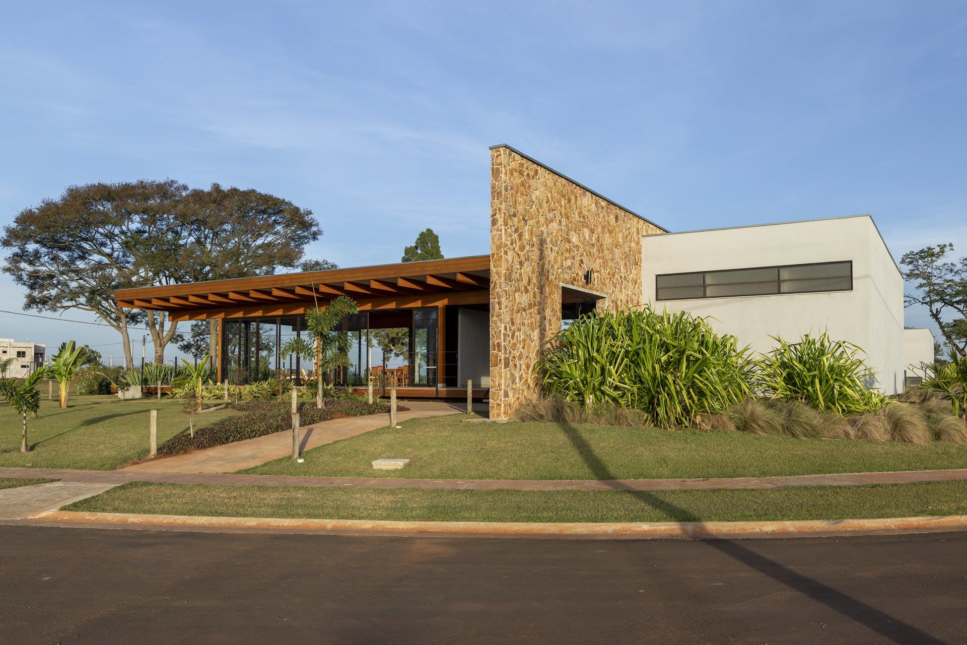 Uma casa com telhado de pedra está situada no topo de uma encosta verdejante.