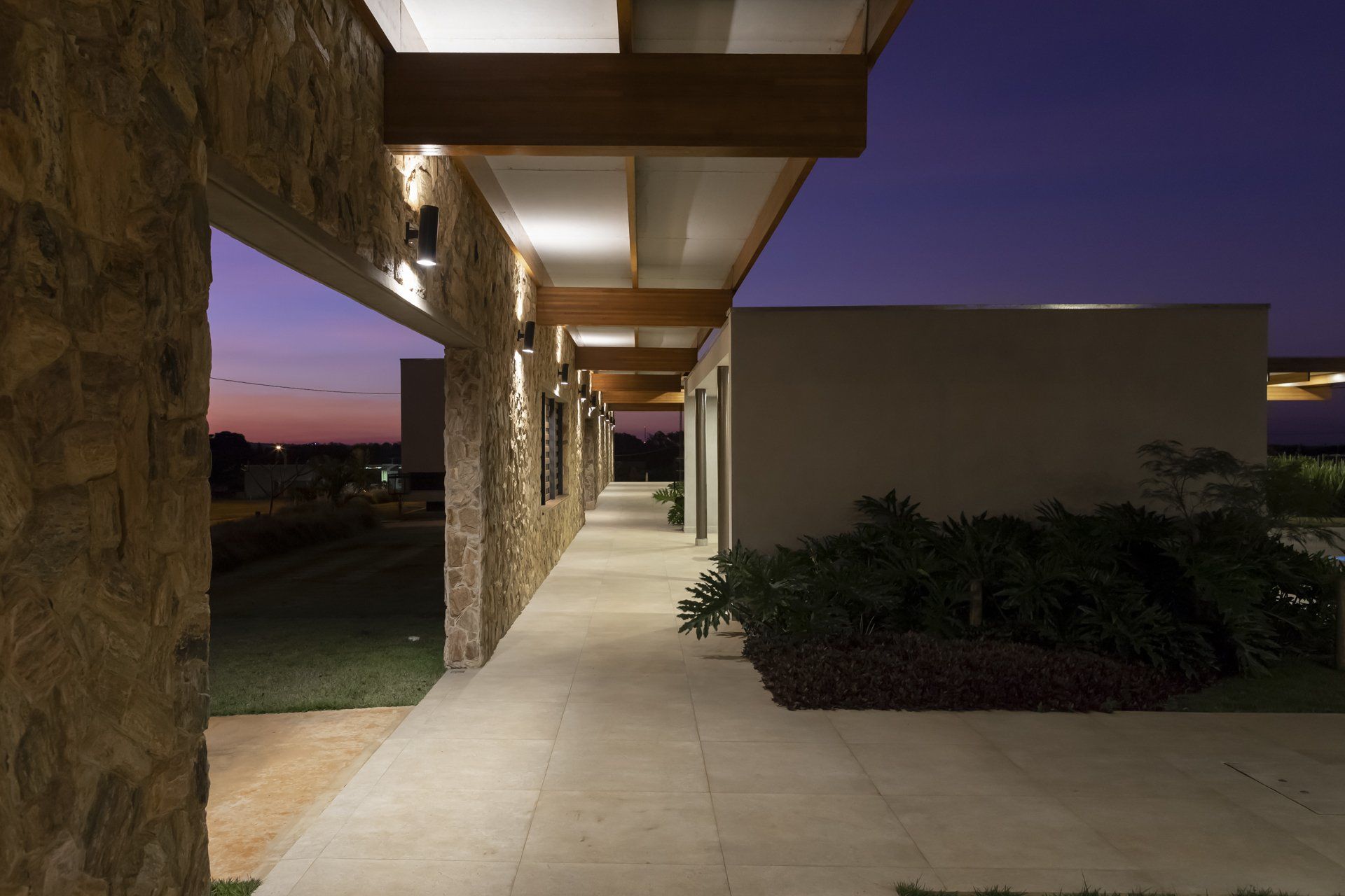 Uma longa passarela entre dois prédios com um pôr do sol ao fundo.