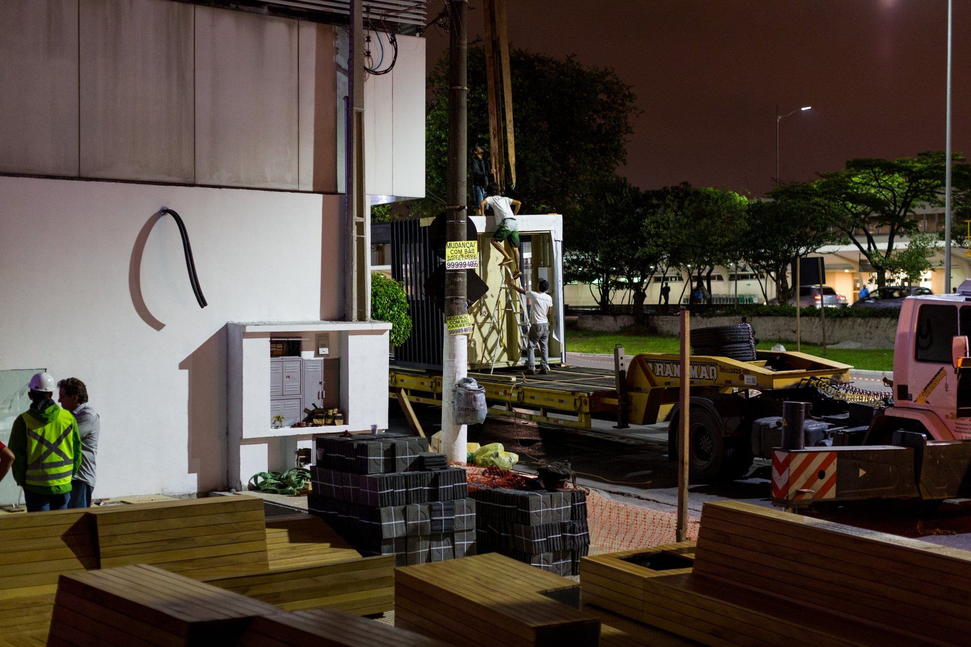 Um grupo de trabalhadores da construção civil está trabalhando em um prédio à noite.