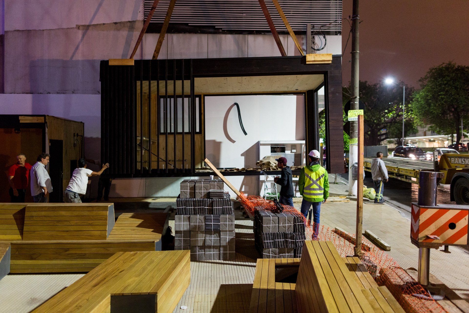 Um grupo de trabalhadores da construção civil está trabalhando em um prédio à noite.