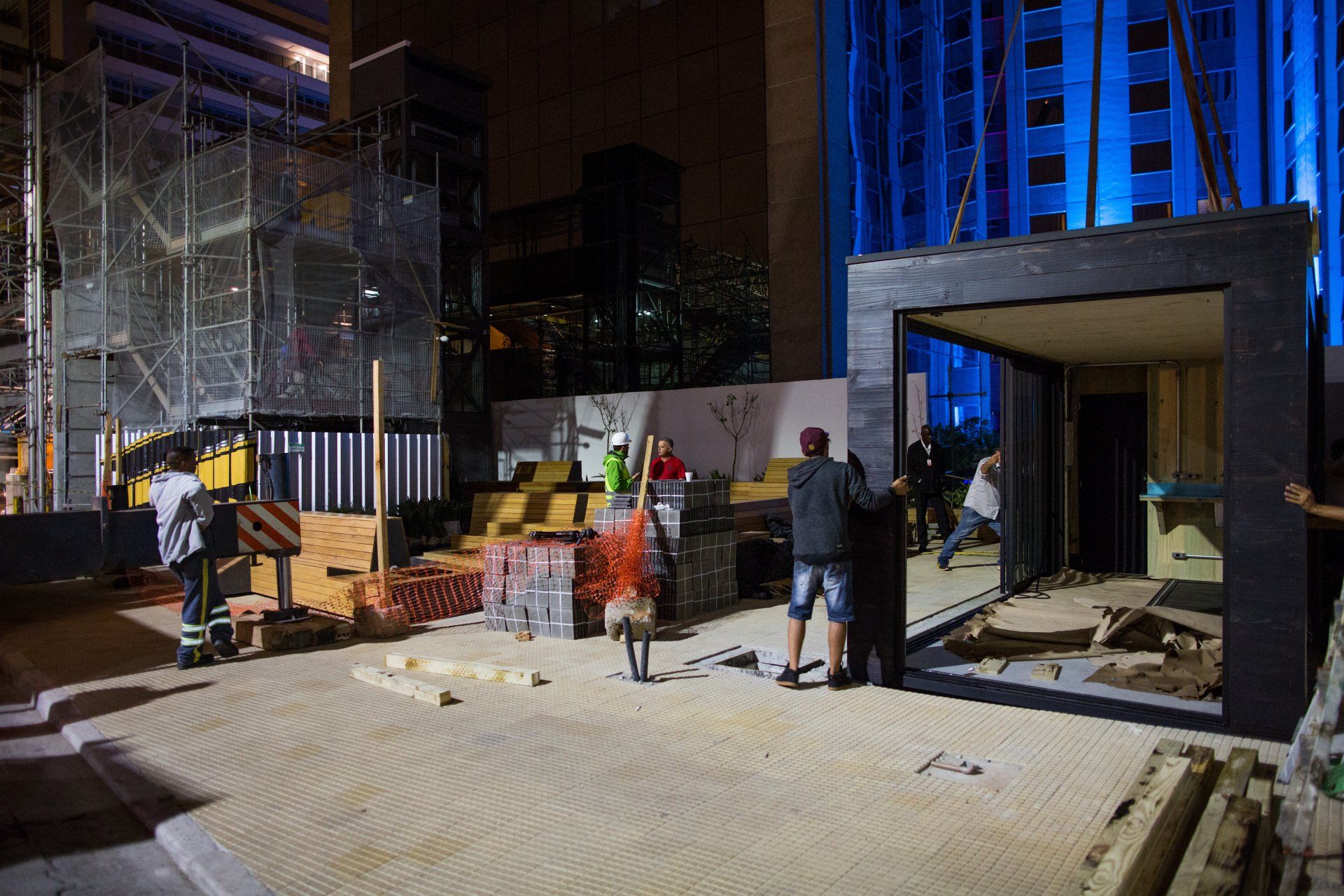 Um grupo de trabalhadores da construção civil está trabalhando em um prédio à noite.