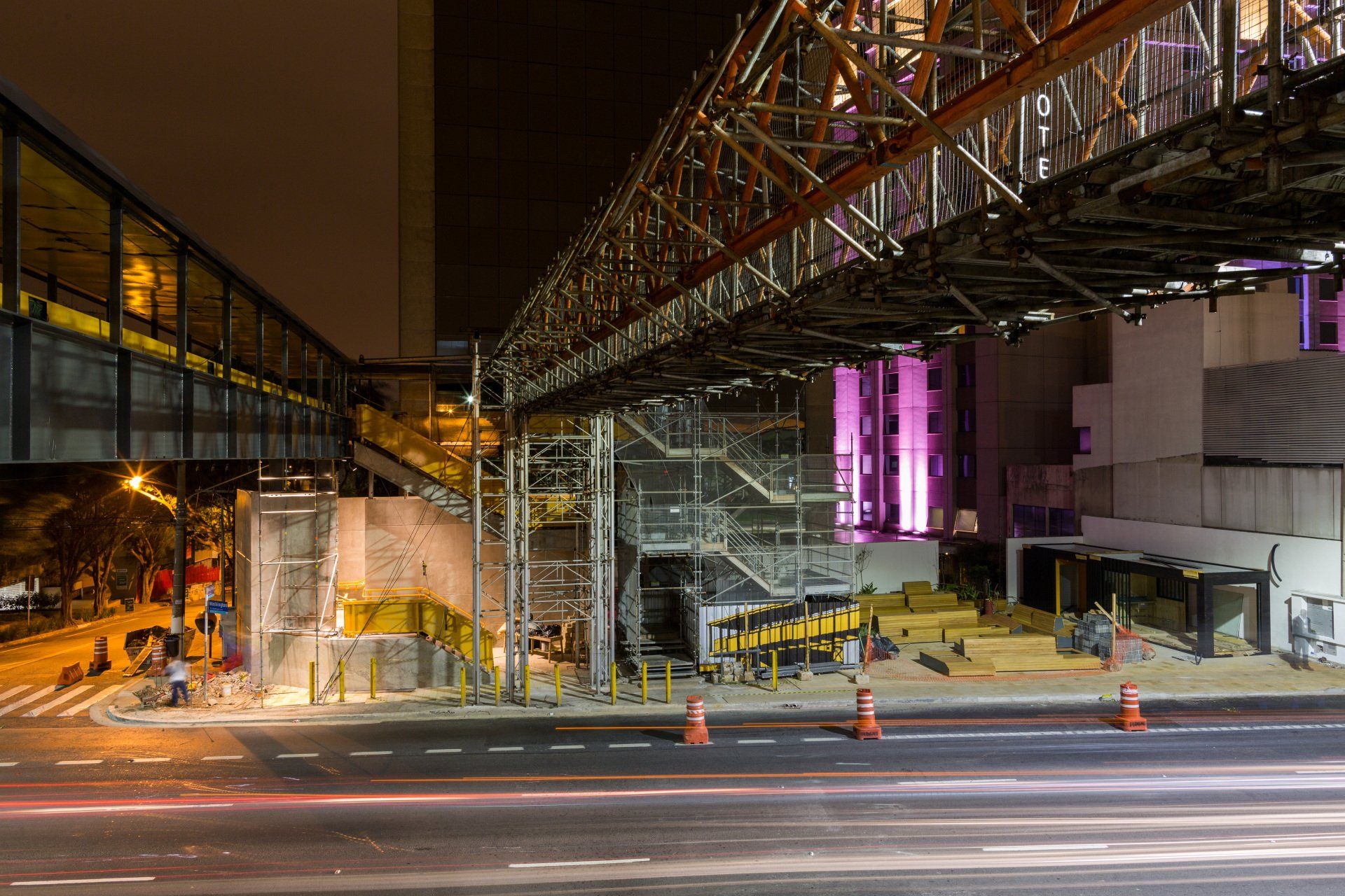 Uma ponte está sendo construída sobre uma rua da cidade à noite.