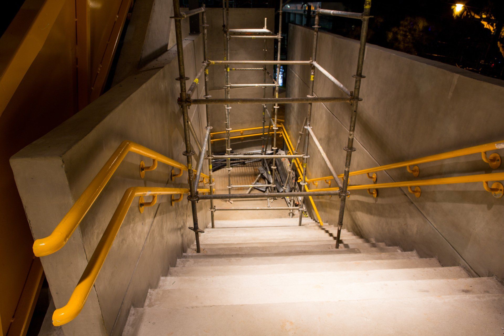 Um conjunto de escadas com corrimãos e andaimes amarelos.