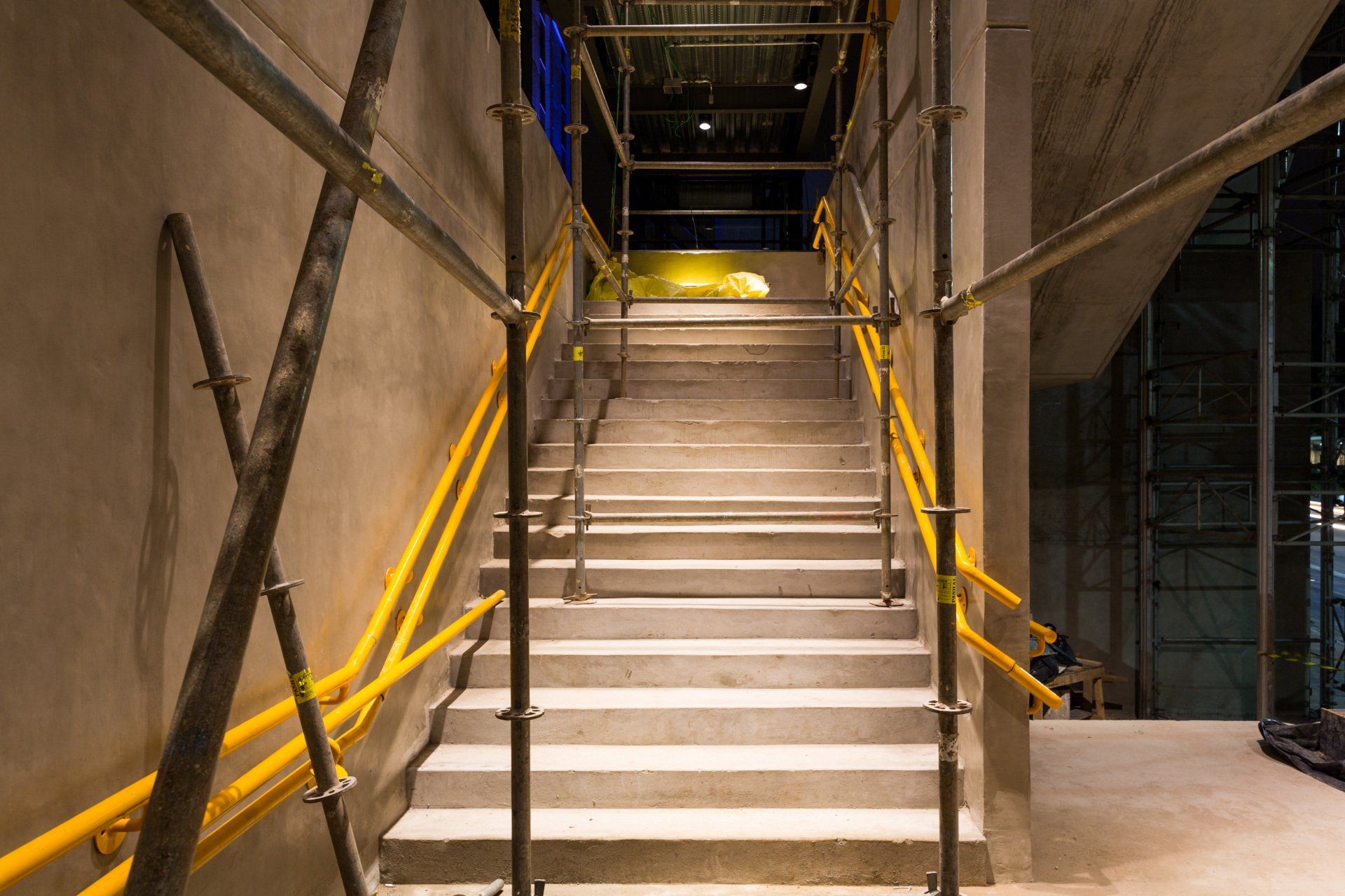 Um conjunto de escadas com corrimãos e andaimes amarelos.