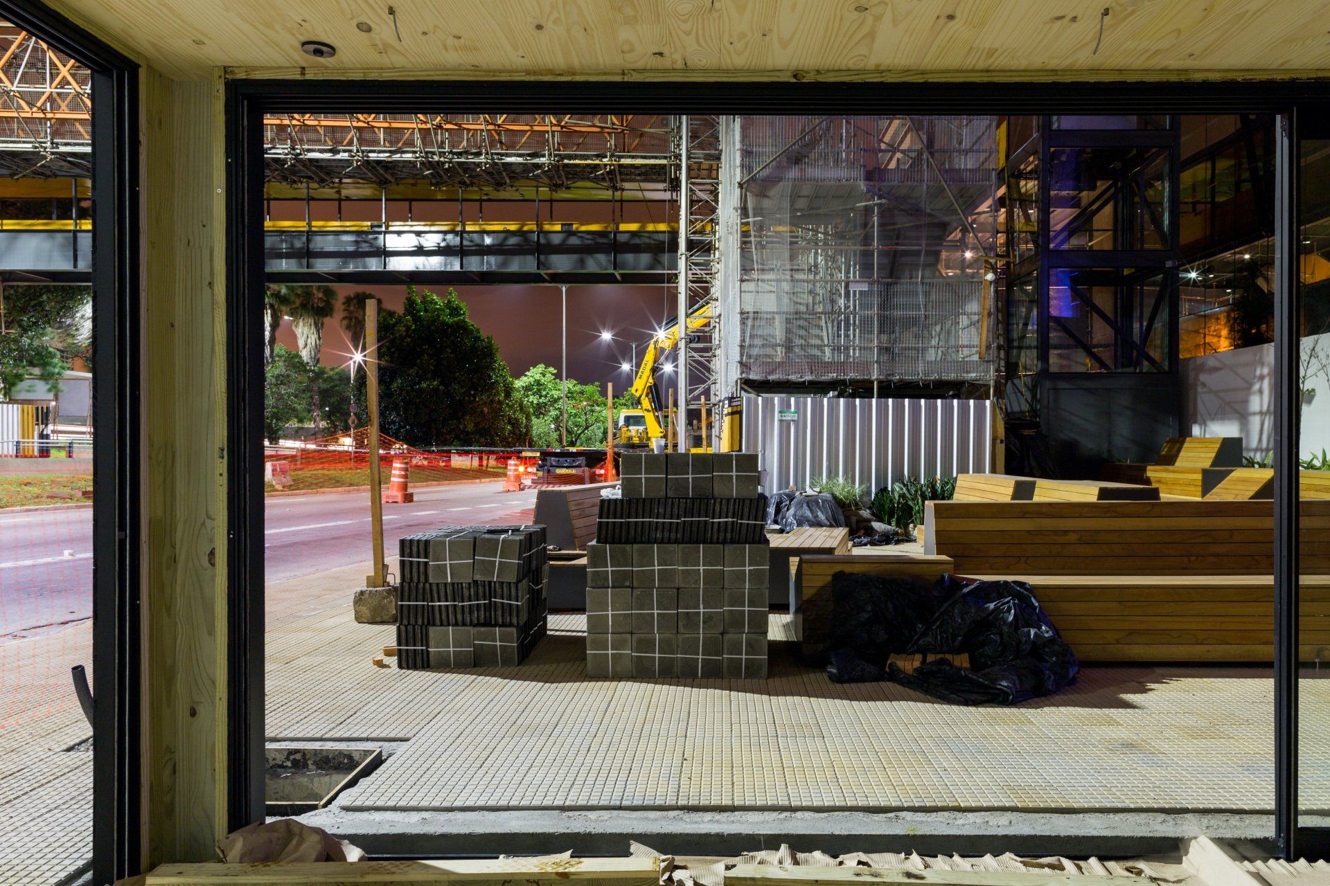 Uma vista de um canteiro de obras através de uma porta de vidro deslizante.