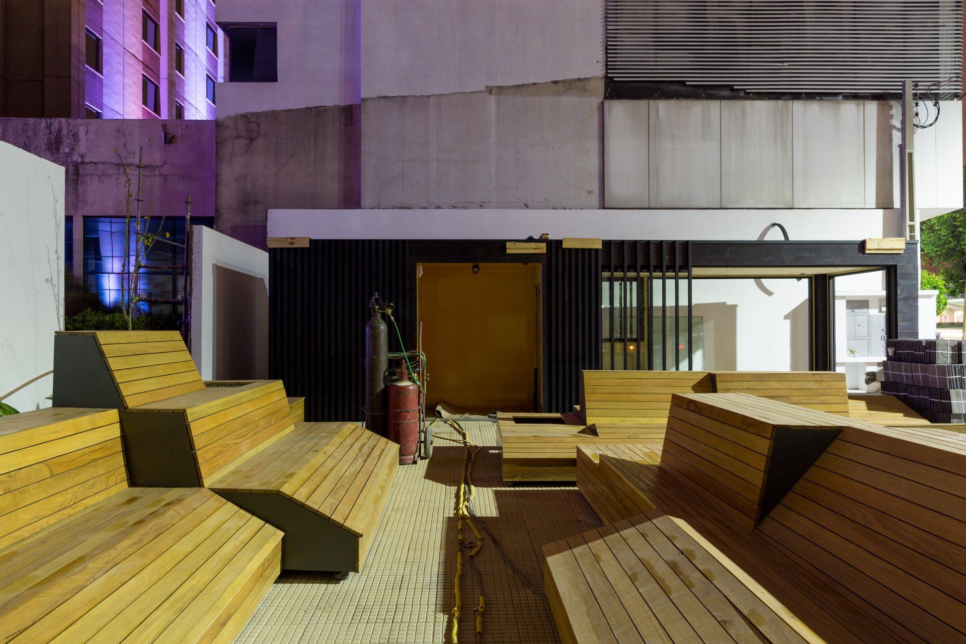 Um grupo de bancos de madeira está sentado em frente a um prédio.