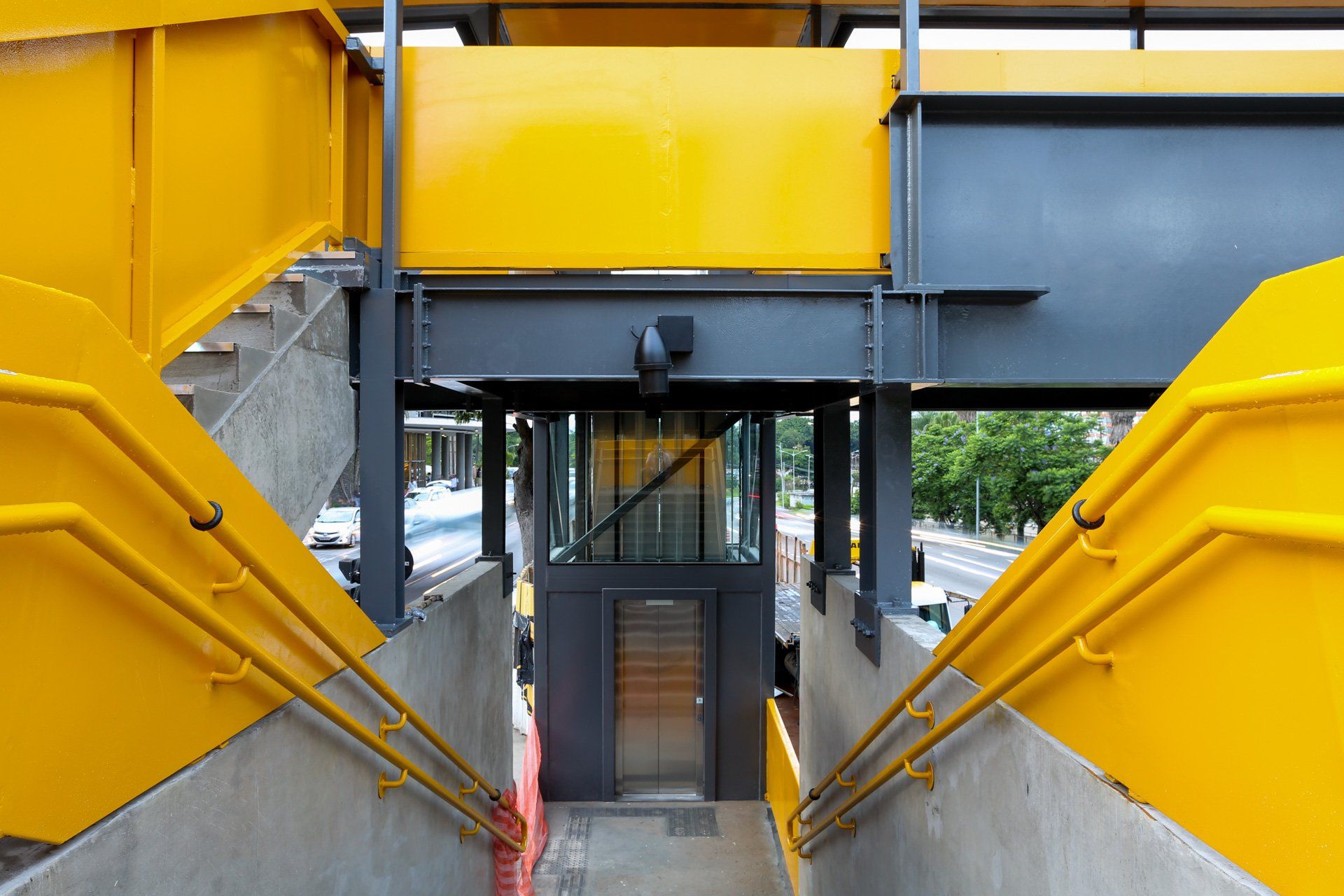 Uma escada amarela e preta que leva até um elevador.