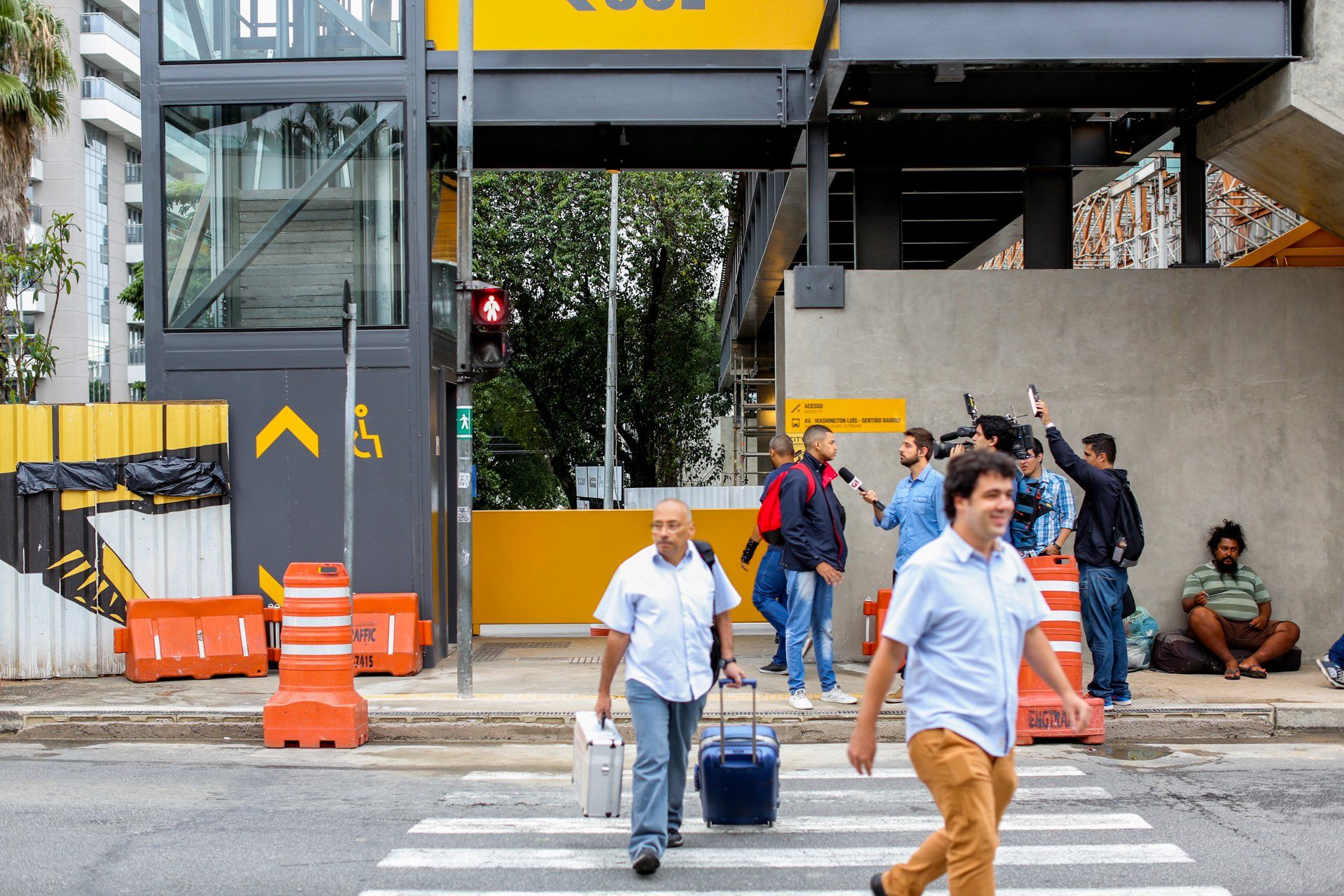 Um grupo de pessoas atravessa uma rua em frente a um prédio.