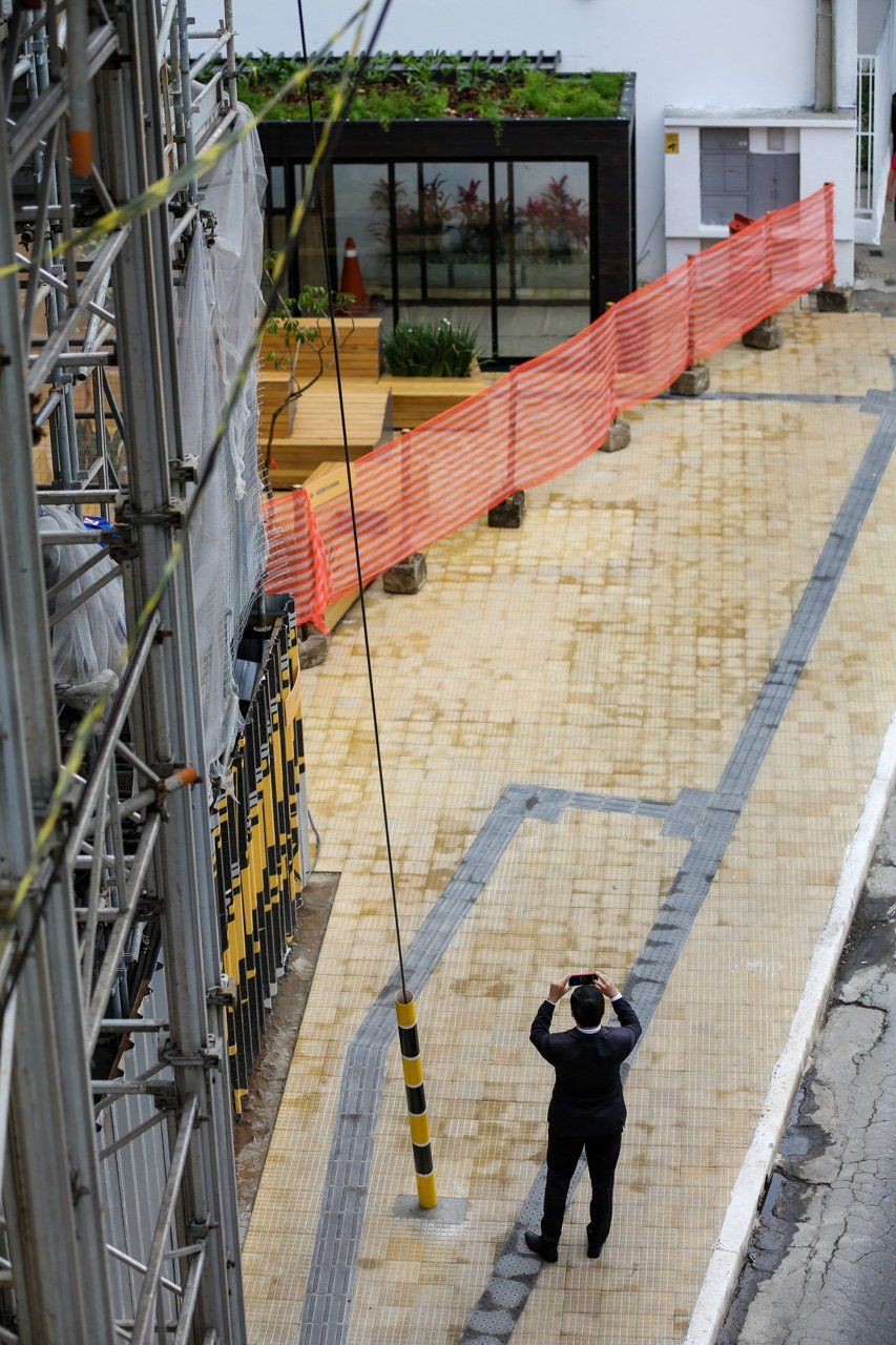 Um homem está tirando uma foto de um prédio em construção.