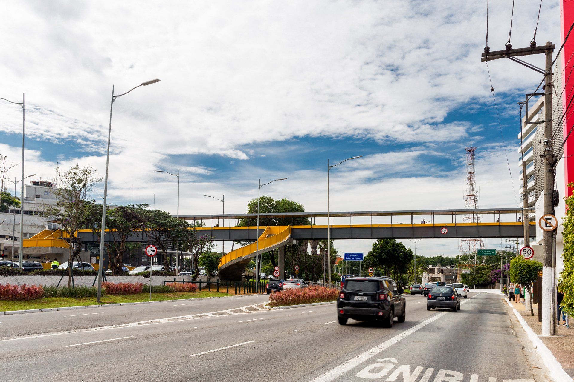 Um carro está passando por uma rua sob uma ponte.