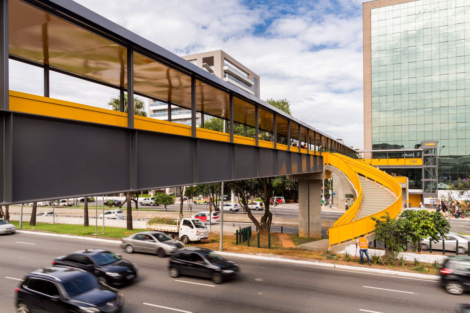 Uma ponte sobre uma rua com carros passando por baixo dela.