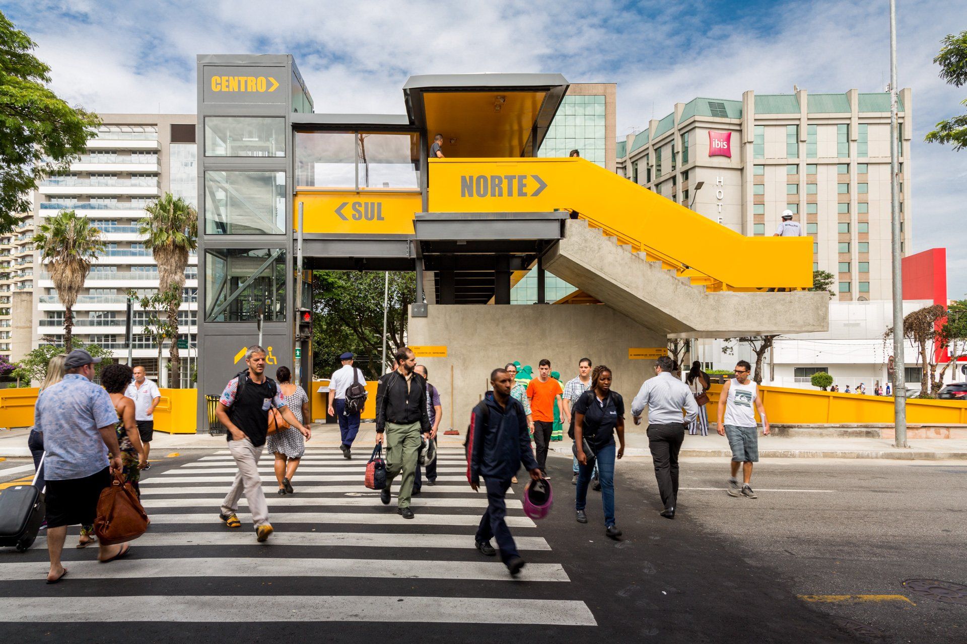 Um grupo de pessoas atravessa uma rua em frente a um prédio que diz norte