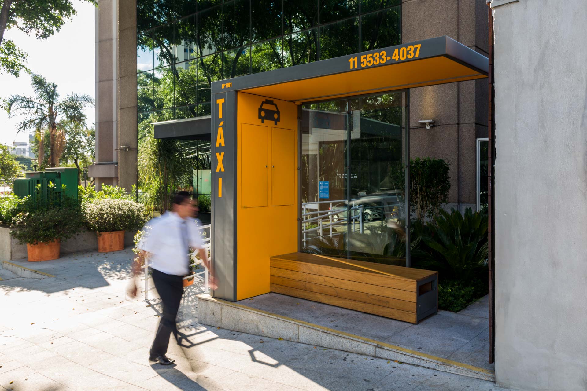 Um homem está passando por um ponto de ônibus que diz táxi.