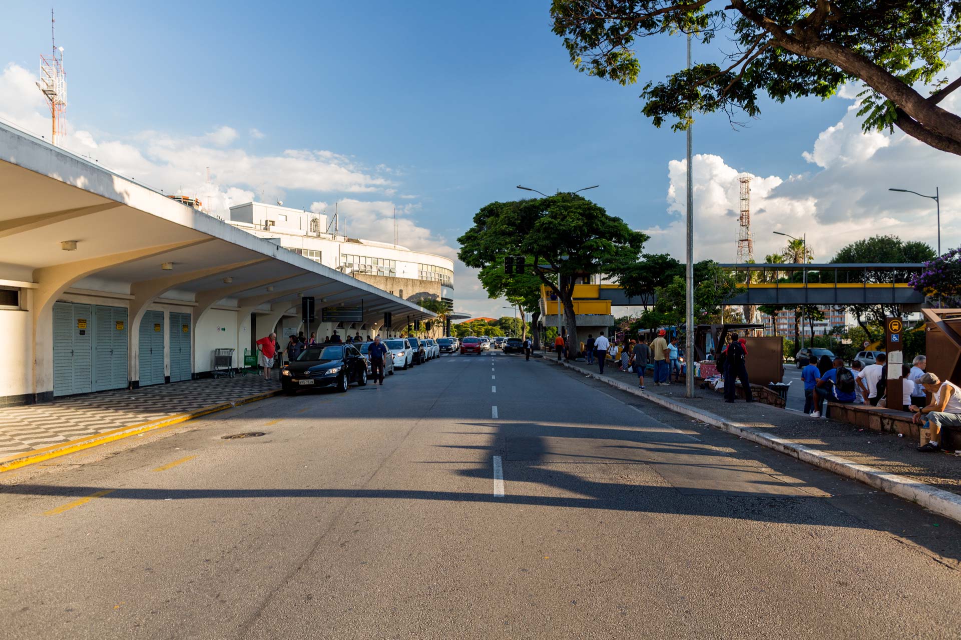 Uma rua com muitos carros estacionados ao lado.