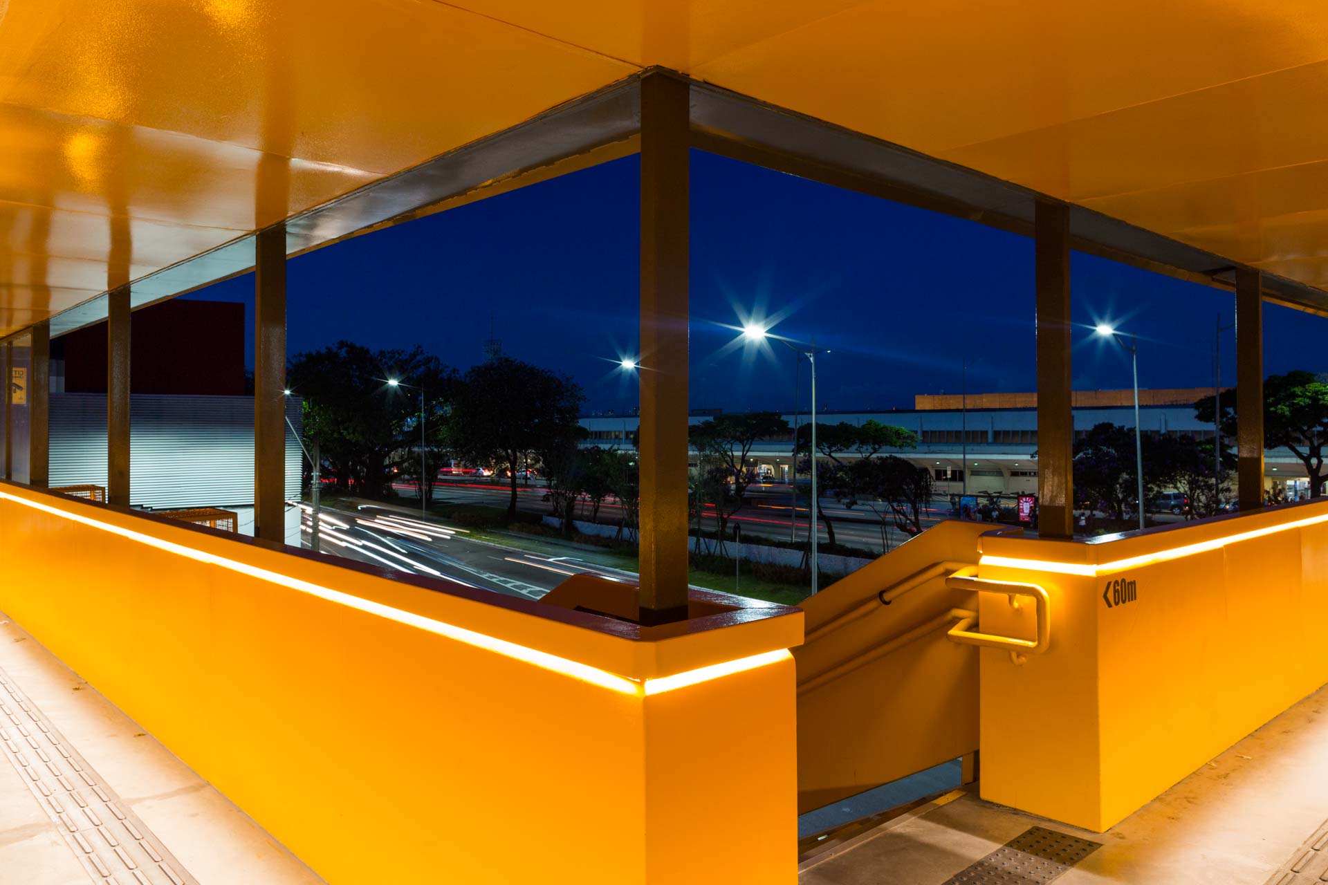 Um prédio amarelo com vista para uma cidade à noite.