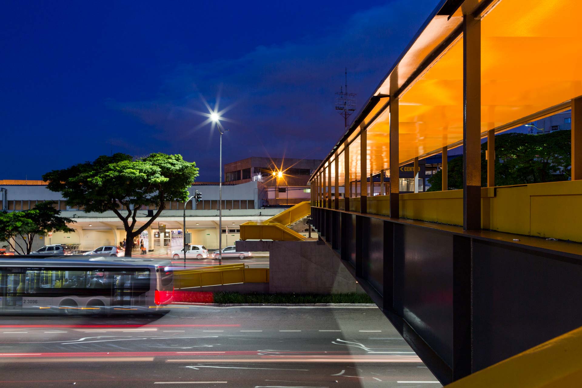 Um ônibus está passando por uma rua da cidade à noite.