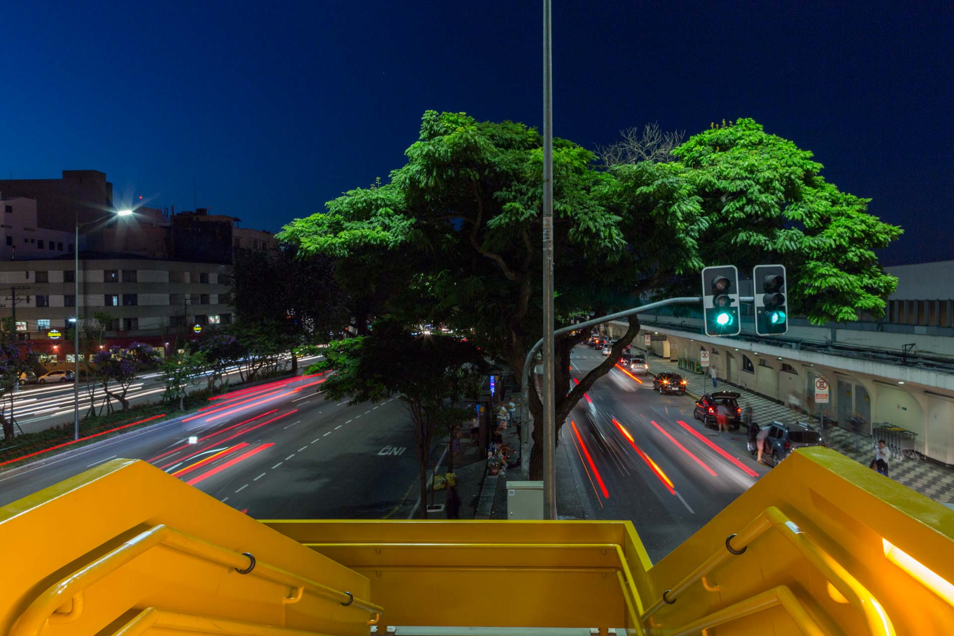 Uma vista de uma rua da cidade à noite a partir de uma ponte.