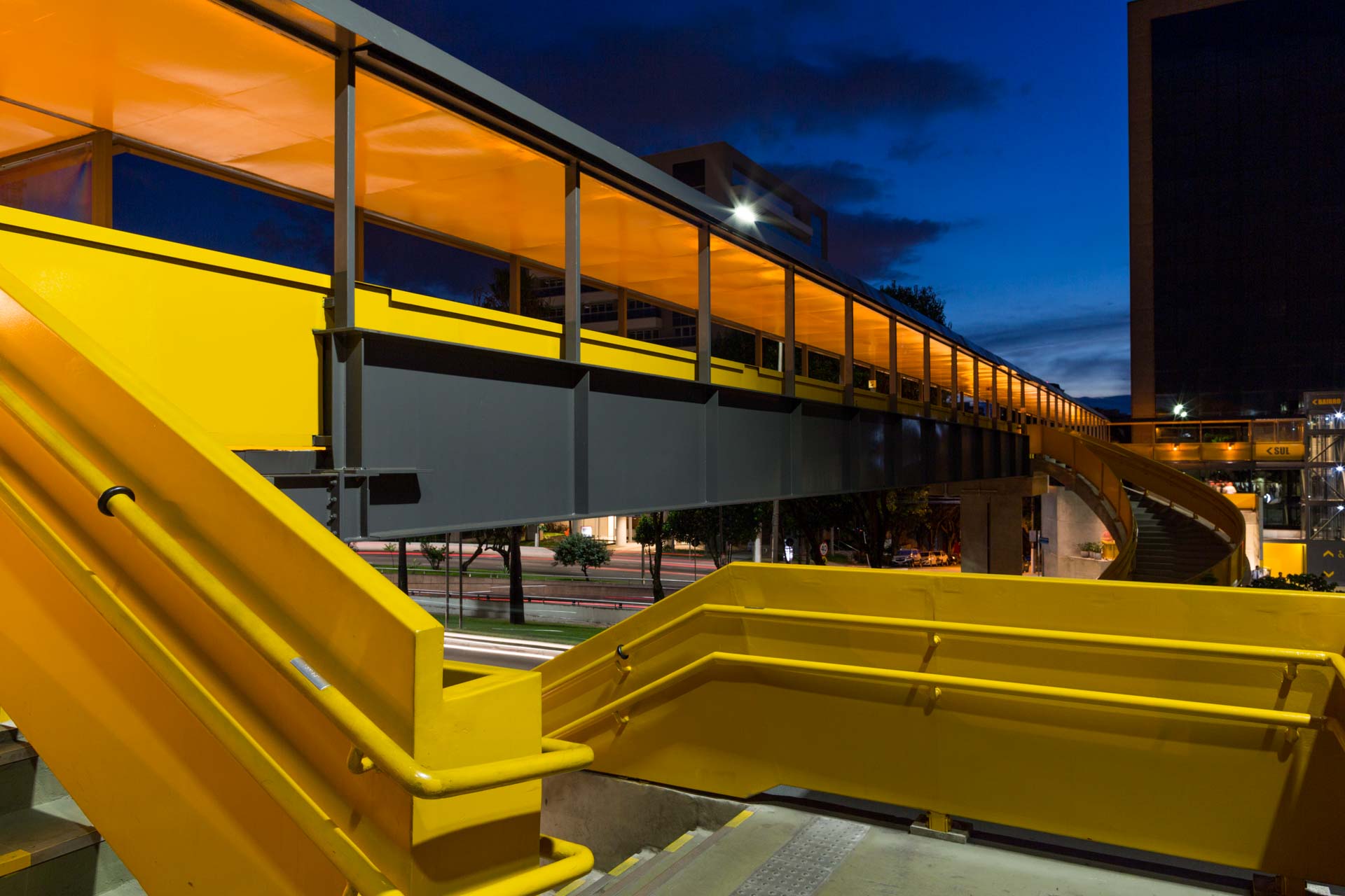 Uma escada amarela que leva a uma ponte à noite.
