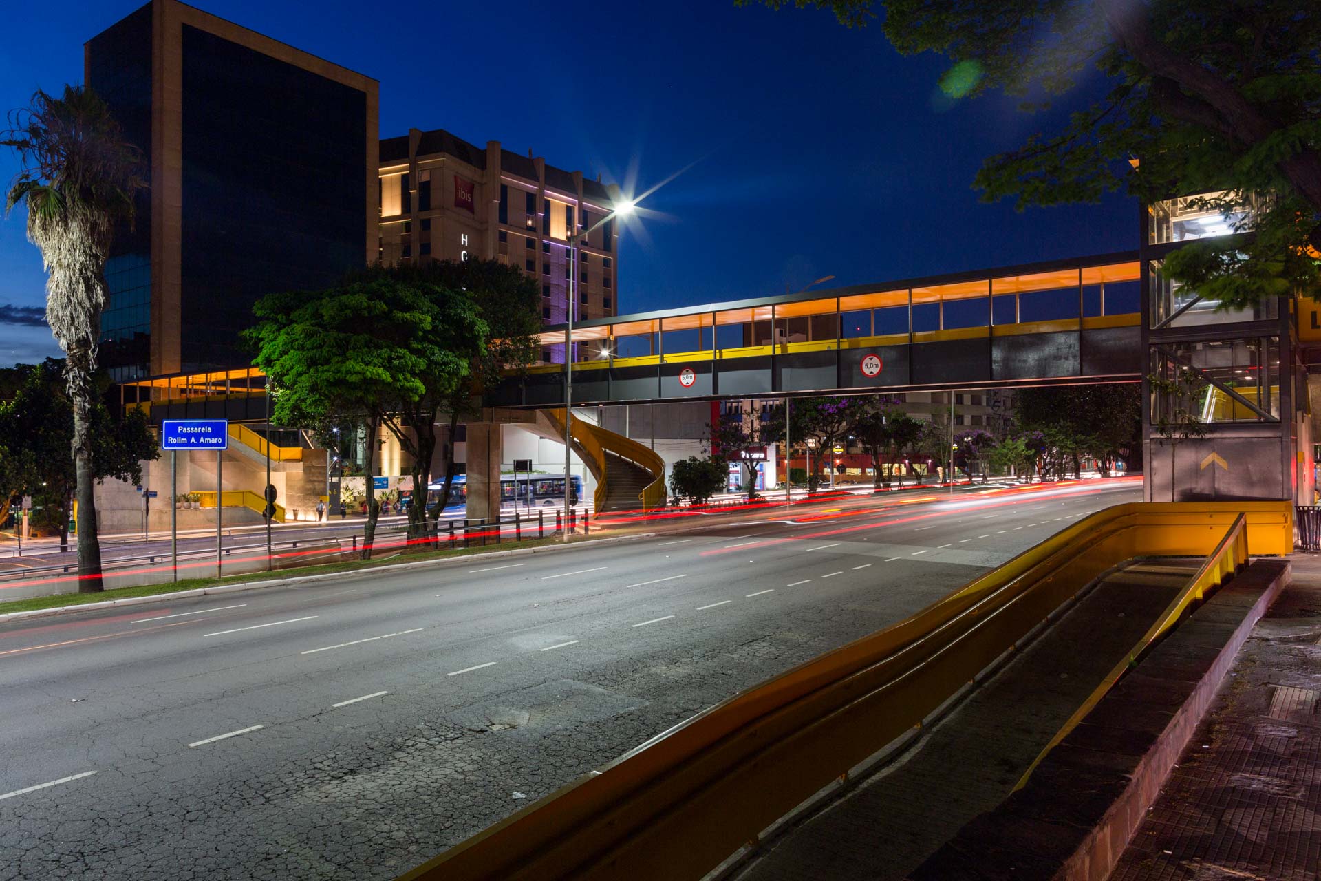 Uma rua movimentada da cidade à noite com um grande edifício ao fundo