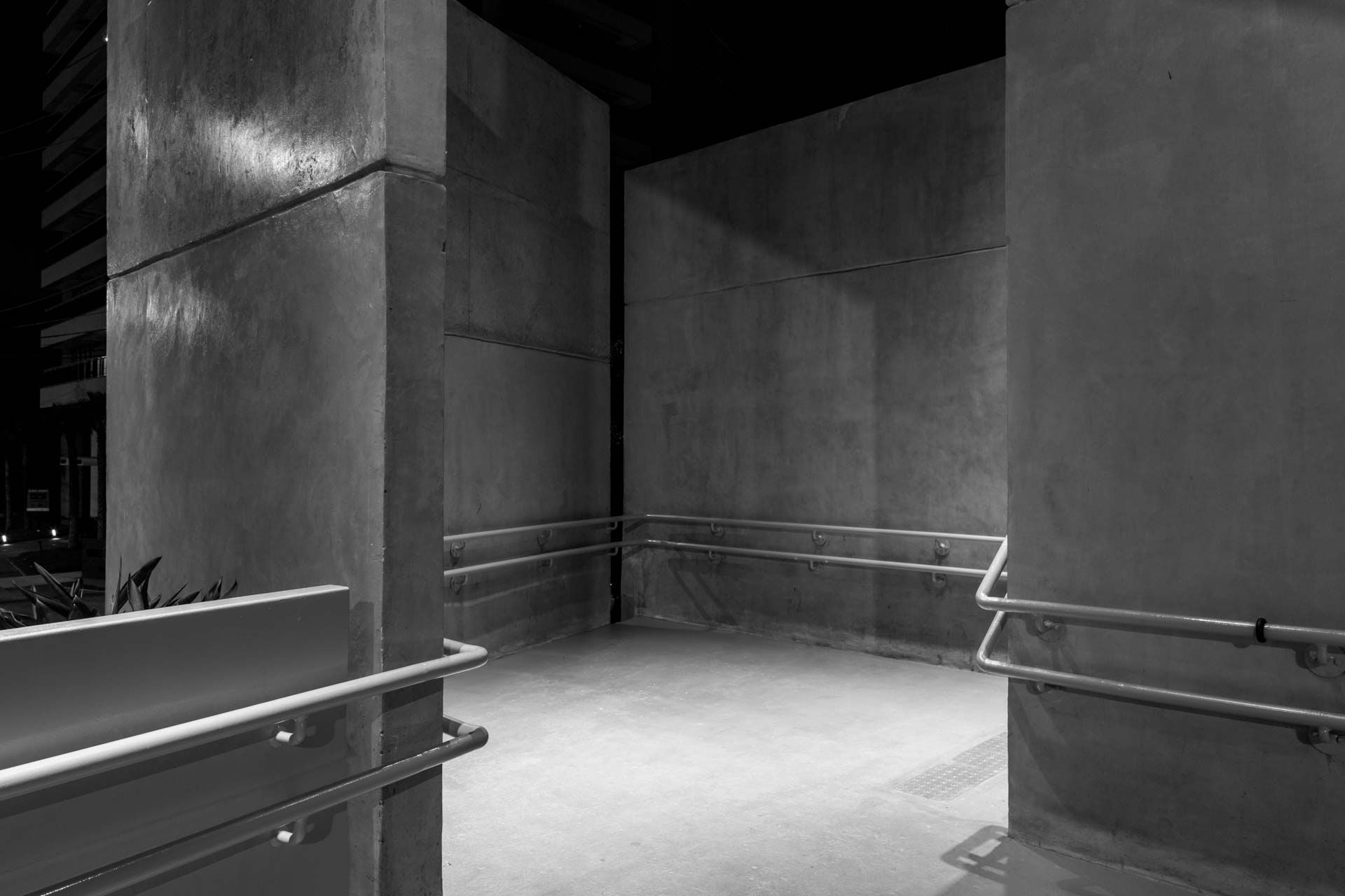 Uma foto em preto e branco de uma passarela de concreto com grade.