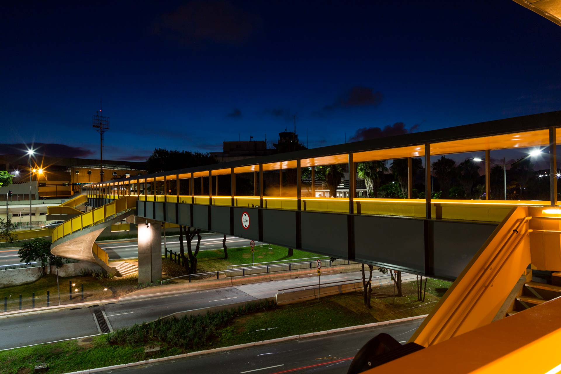 Uma ponte sobre uma estrada à noite com luzes acesas
