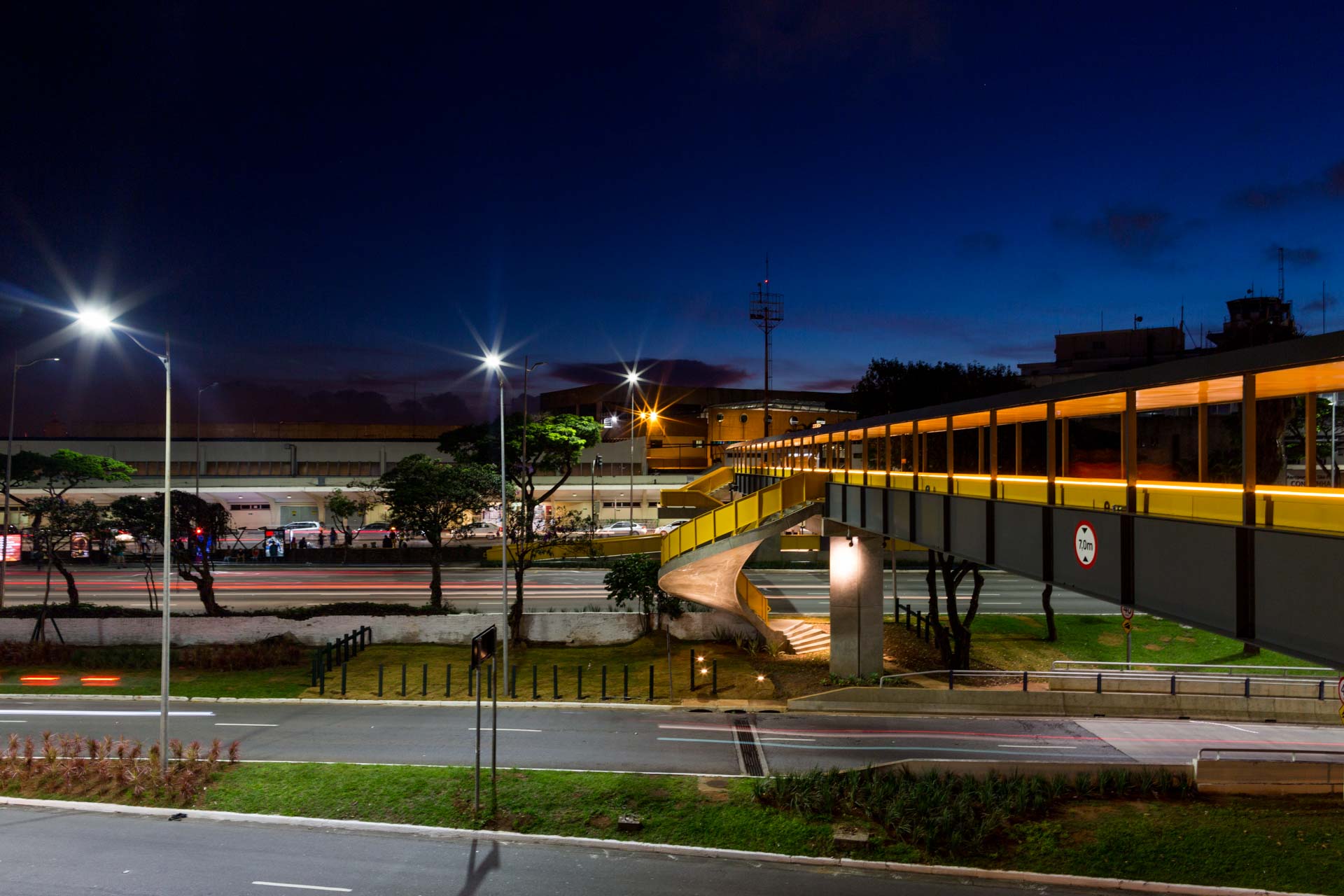 Uma ponte sobre uma estrada à noite com muitas luzes acesas
