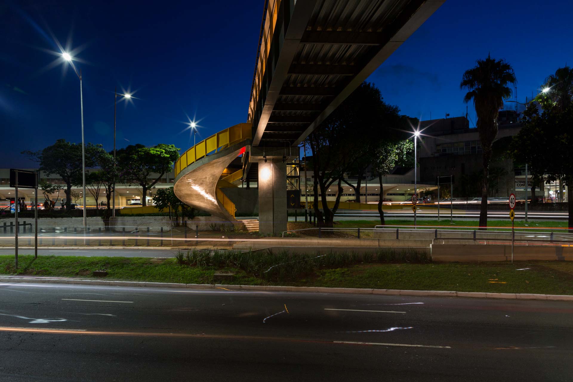 Uma ponte sobre uma estrada à noite com muitas luzes