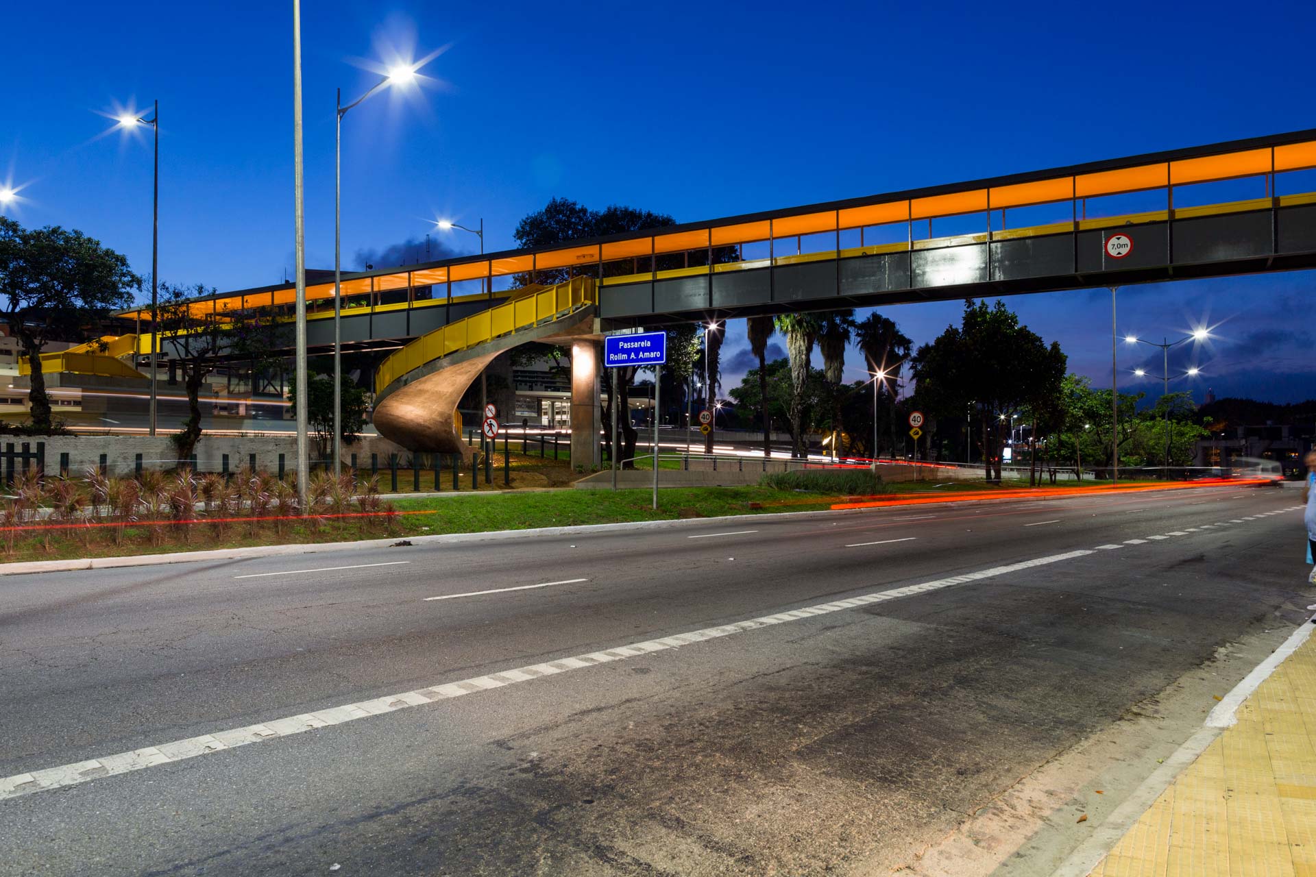 Uma ponte sobre uma estrada à noite com uma placa que diz 'a'