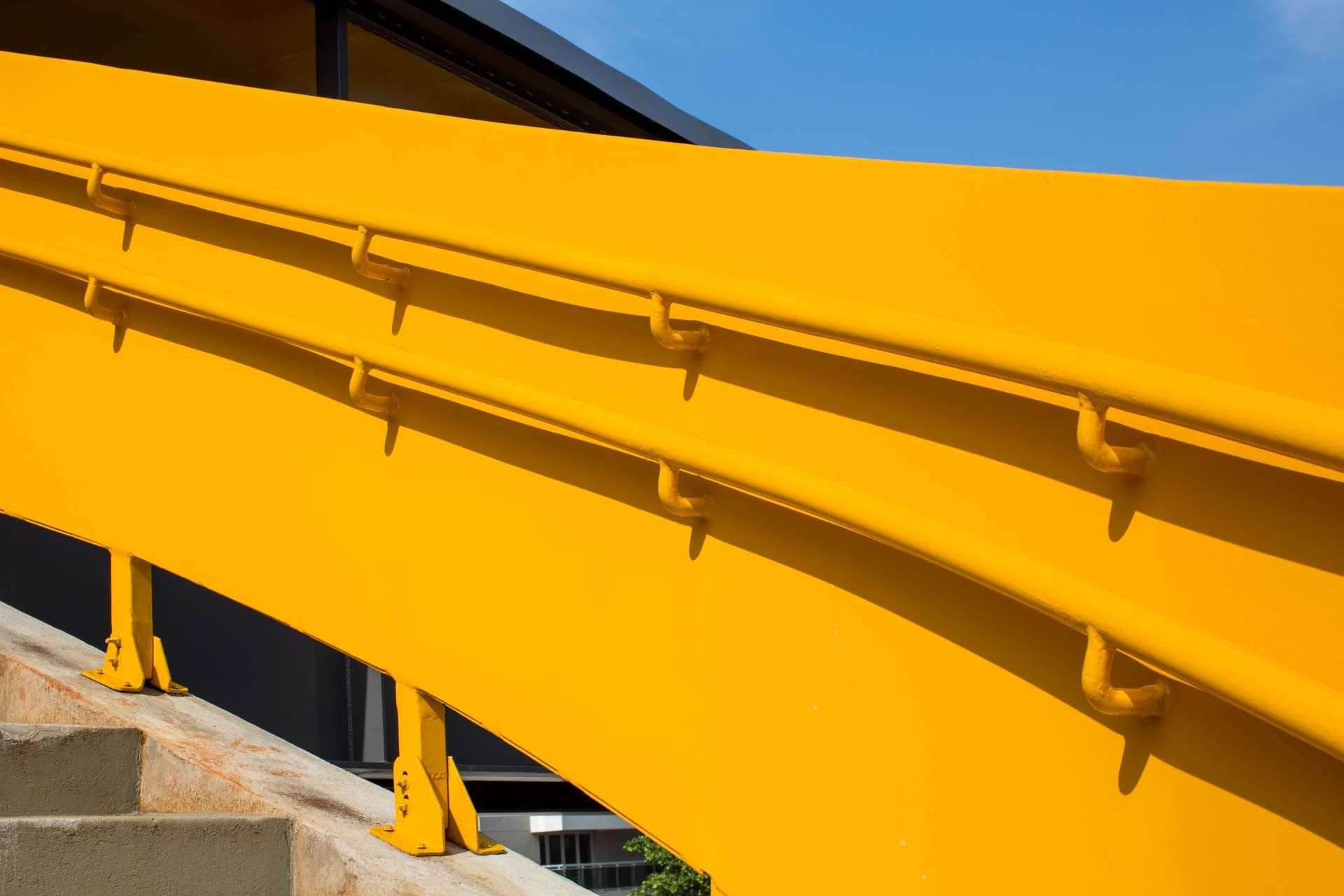 Um close de um corrimão amarelo em um lance de escadas