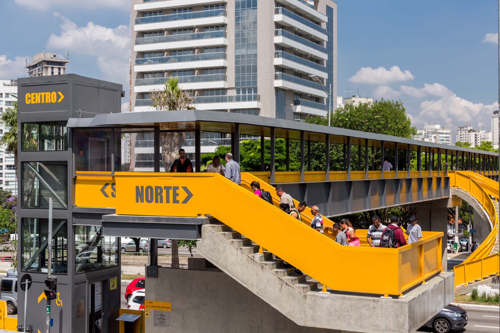 As pessoas estão atravessando uma ponte que diz norte