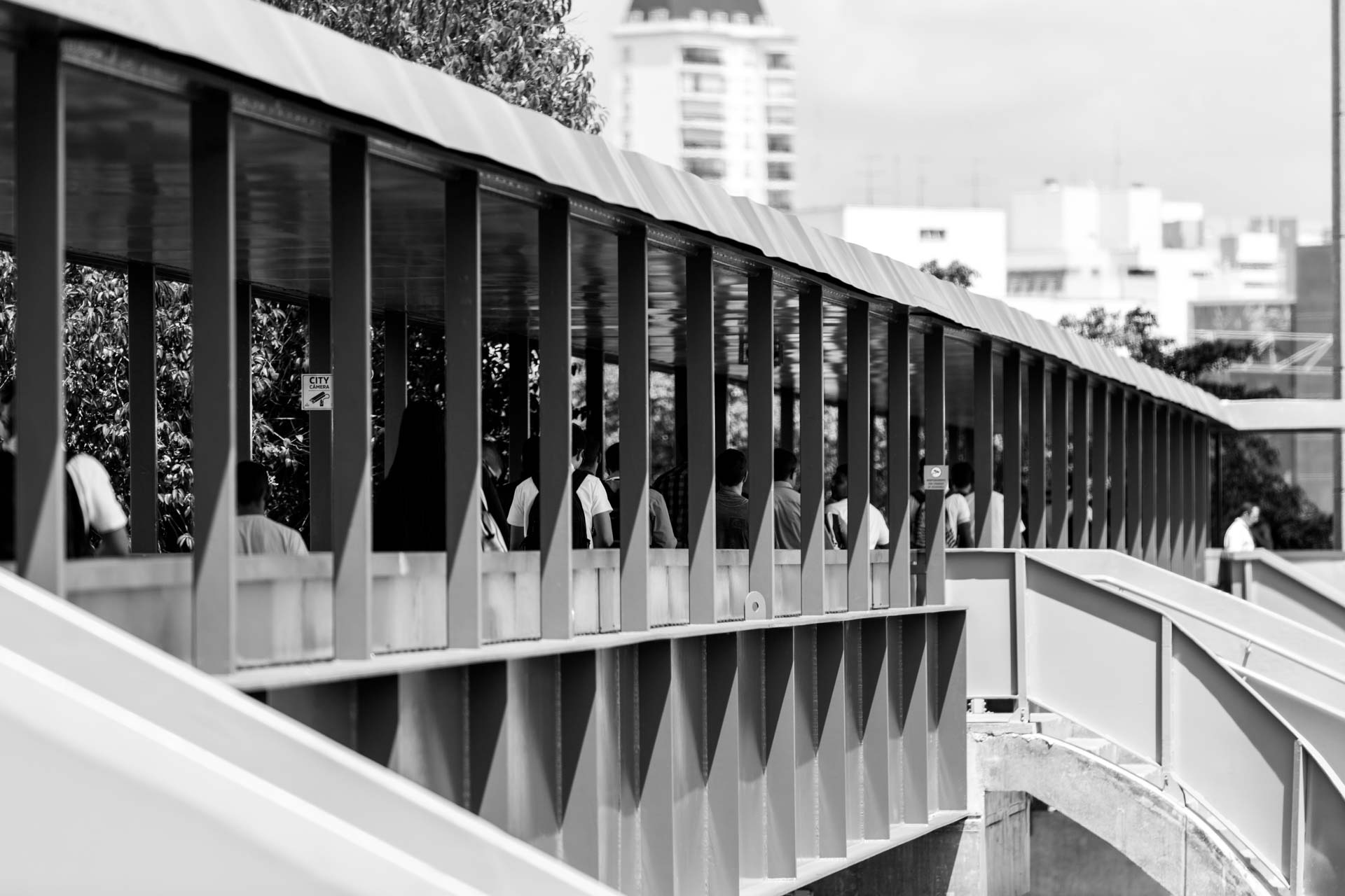 Uma foto em preto e branco de pessoas atravessando uma ponte