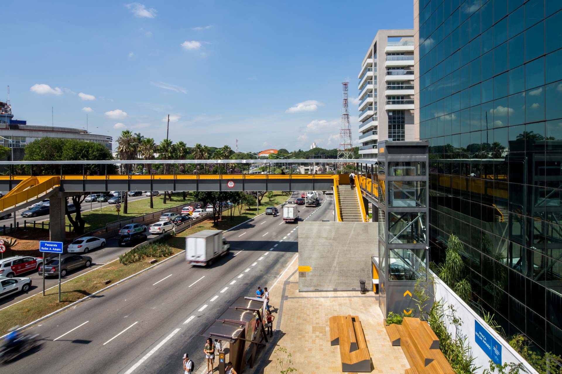 Uma rodovia com uma ponte sobre ela e um prédio ao fundo.