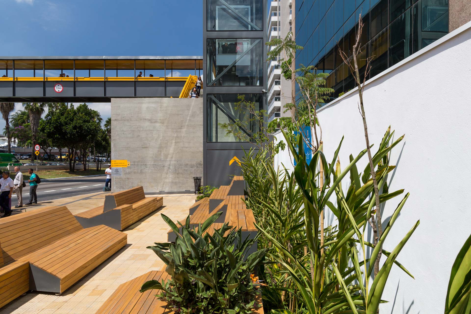 Uma fileira de bancos de madeira está em frente a um prédio.