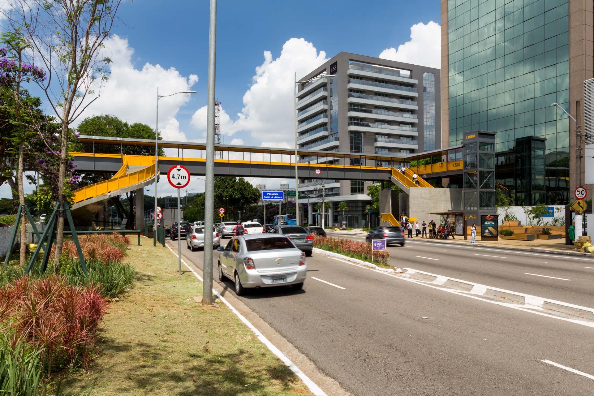Um carro está passando por uma rua da cidade sob uma ponte.