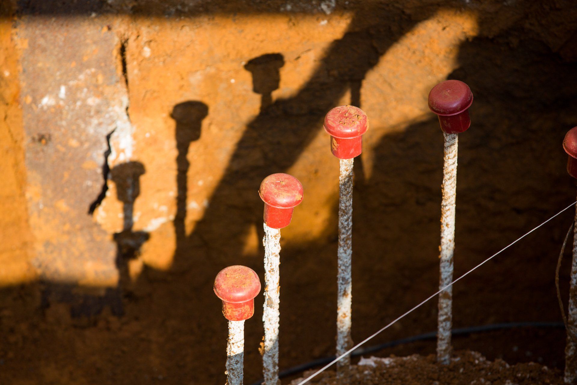Uma fileira de postes de metal com tampas vermelhas